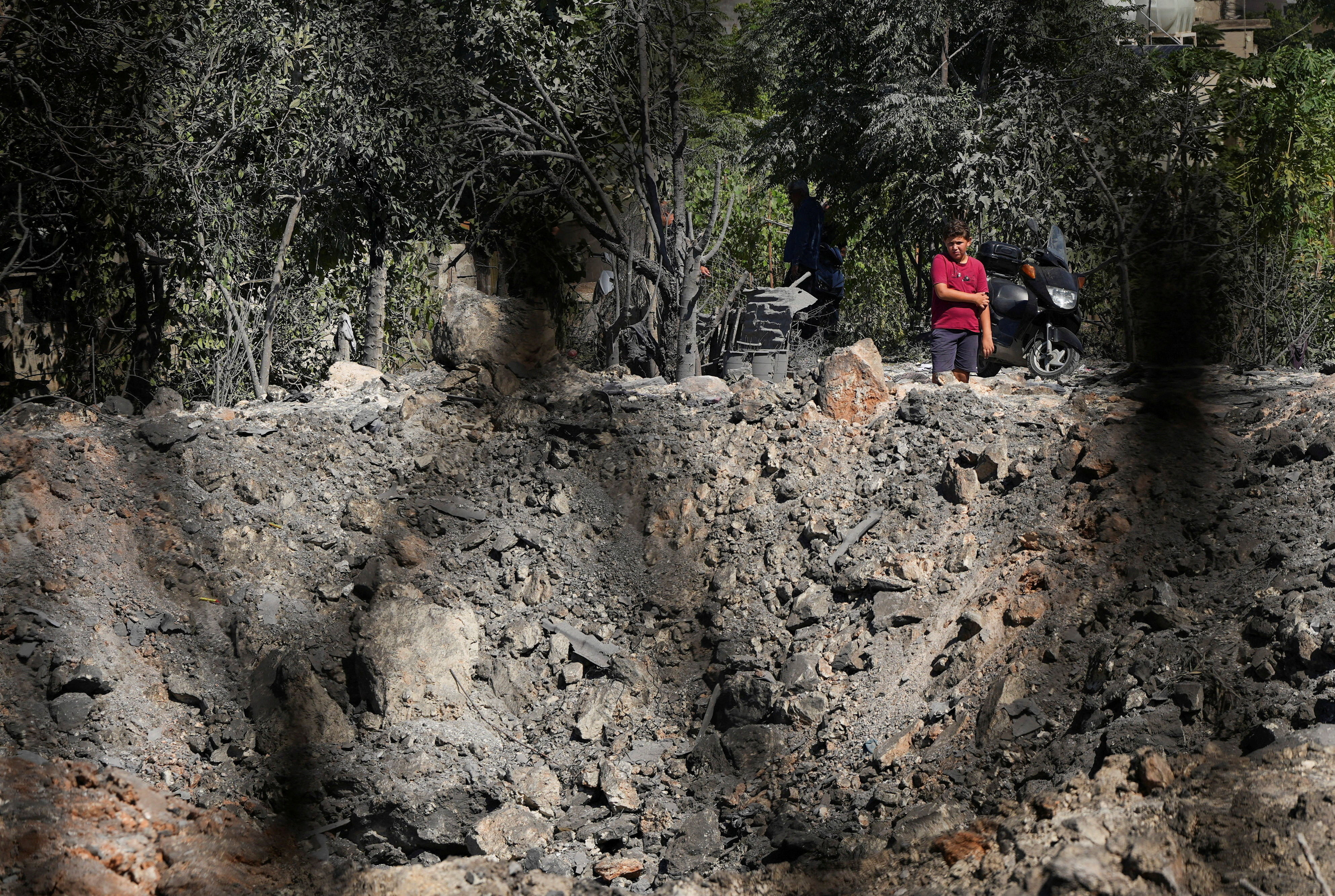 People and journalists stand at a site hit by Israeli strikes that occurred in the early hours of Thursday, according to Lebanon’s state news agency NNA, in Burj al-Shamali, southern Lebanon, August 6, 2026. REUTERS/Stringer