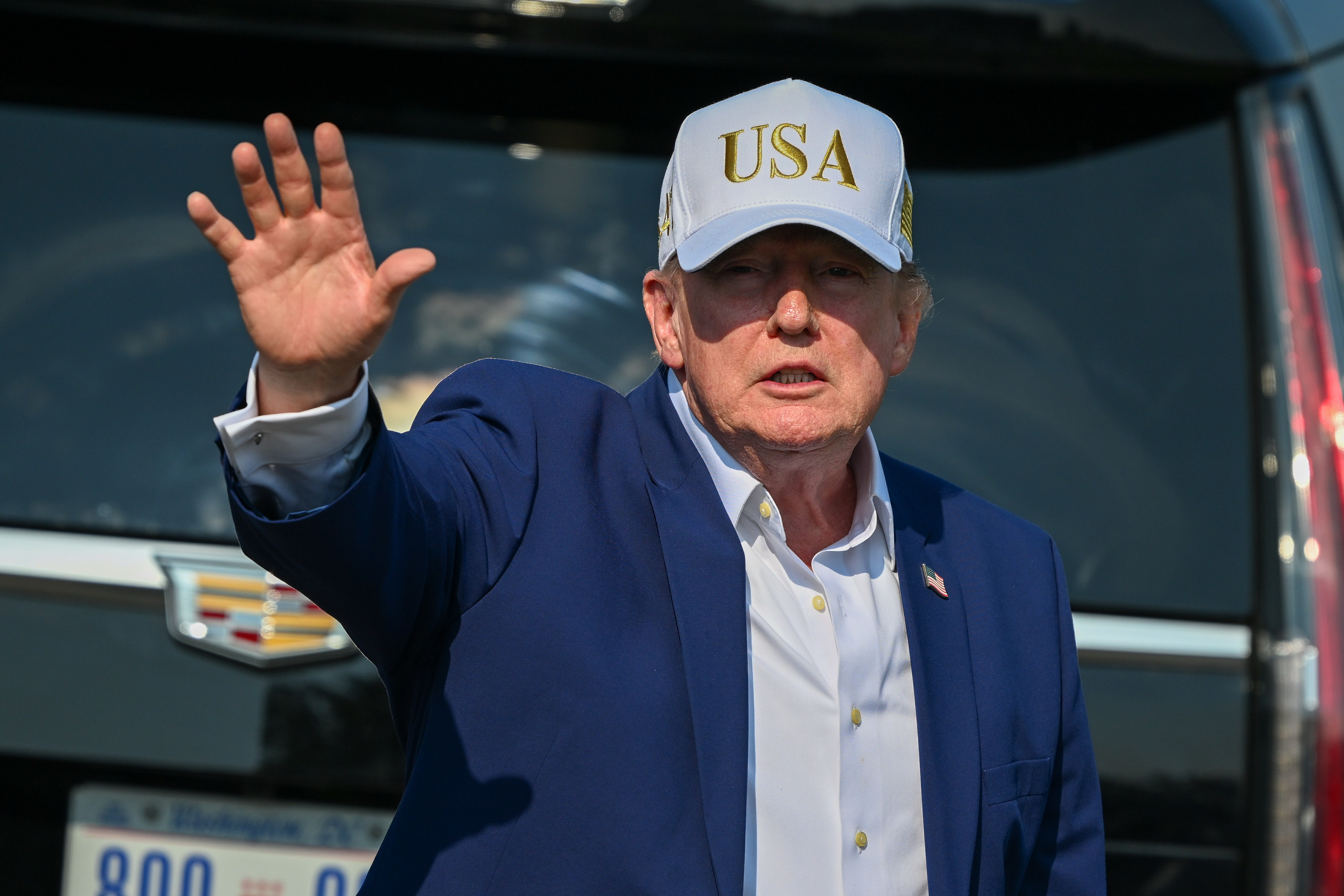 A man in a hat waves