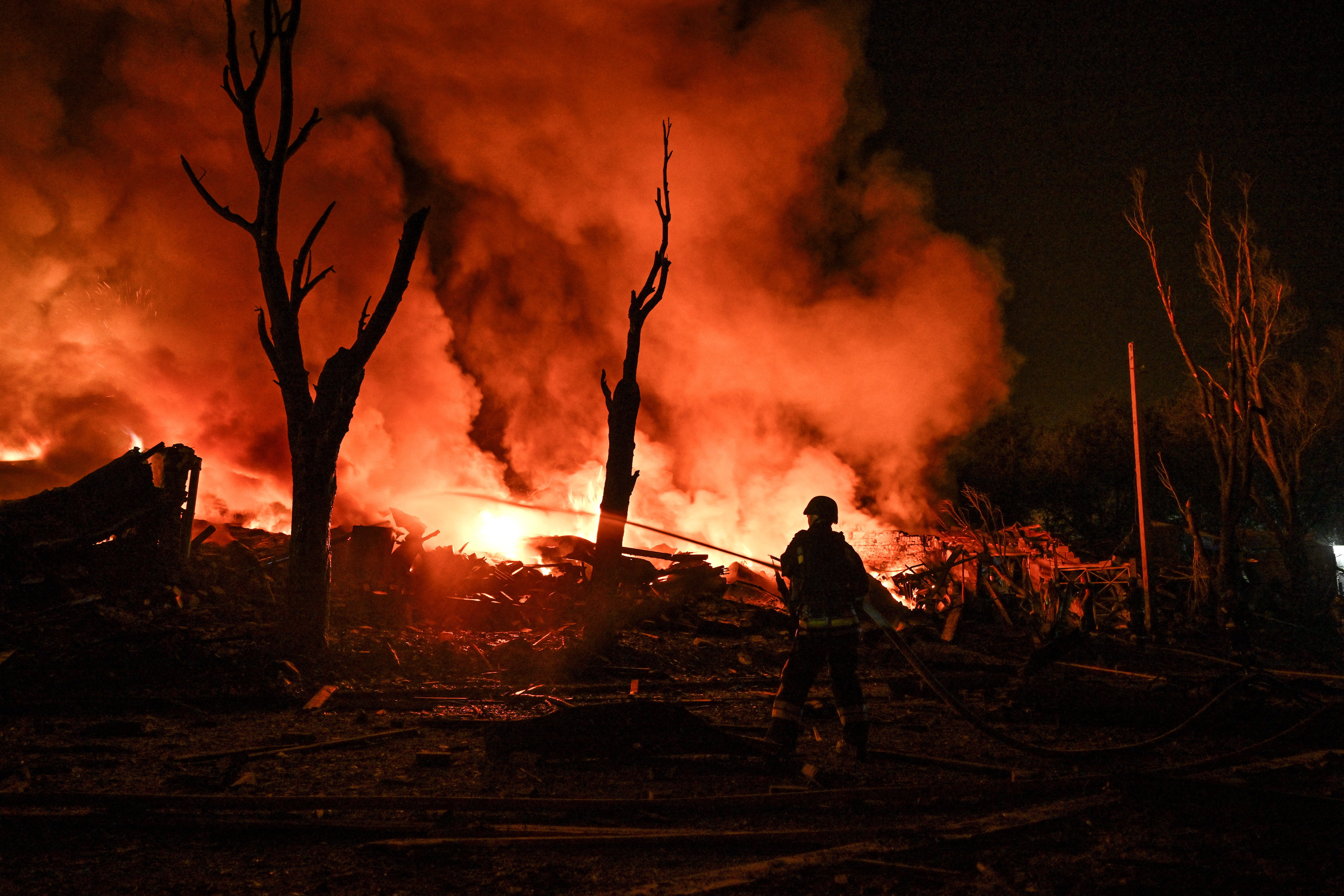 A firefighter works at the site of a fire.