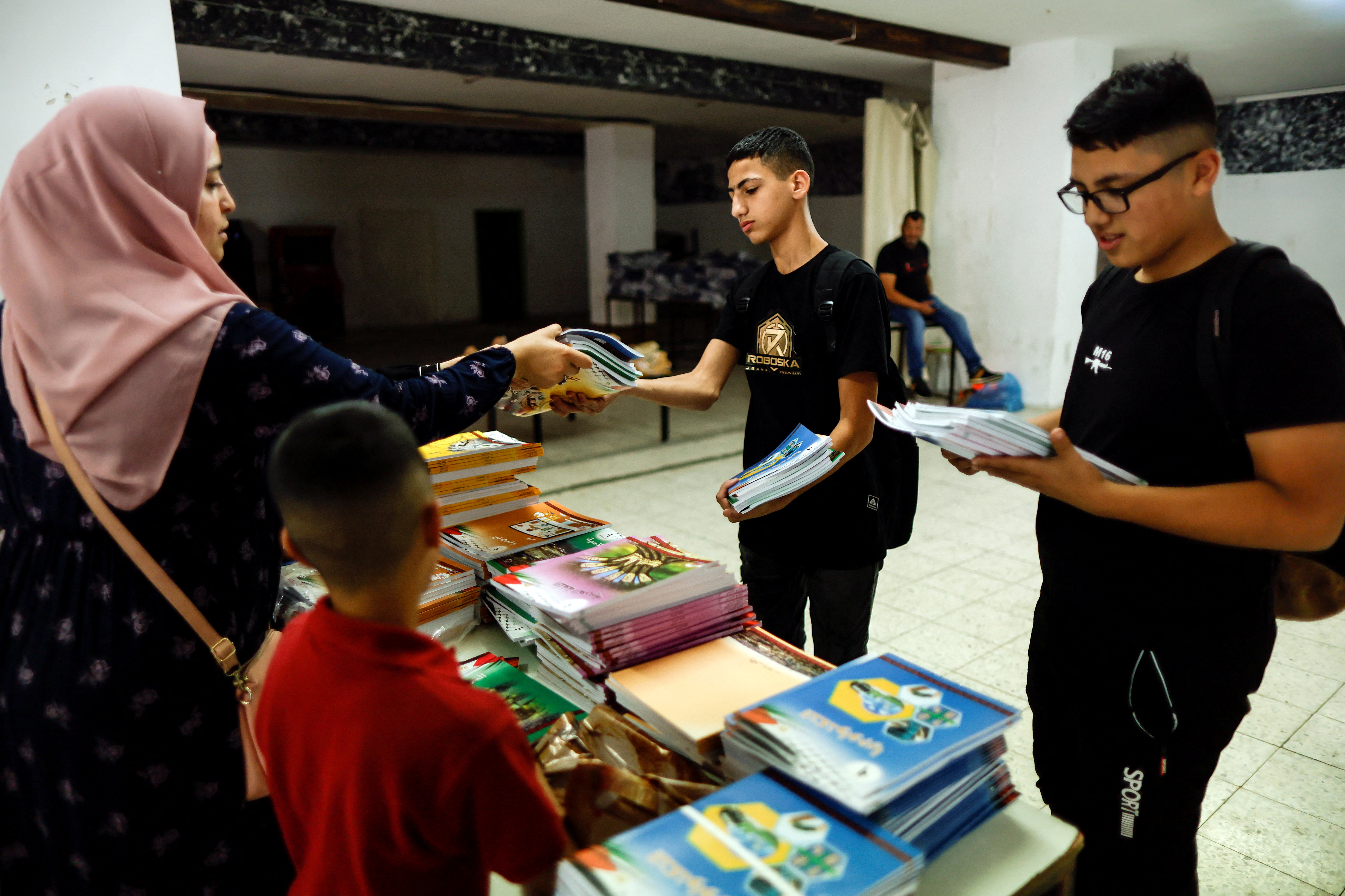 Schoolboys collect unedited textbooks as part of a protest by Palestinian parents of what they say is Israeli censorship of school textbooks in Shuafat refugee camp in East Jerusalem October 1, 2022. REUTERS/Ammar Awad