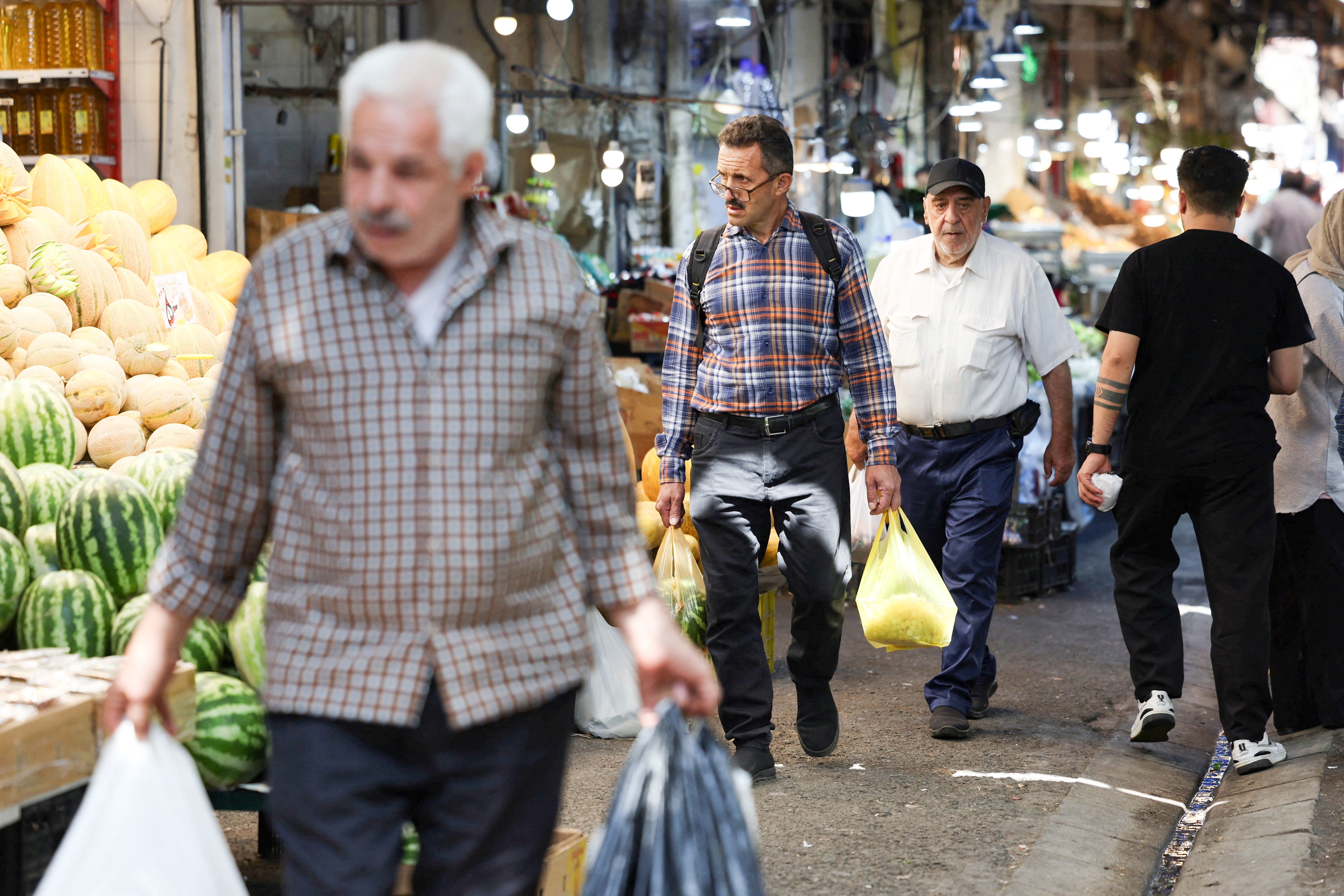 People walk at a local market in Tehran