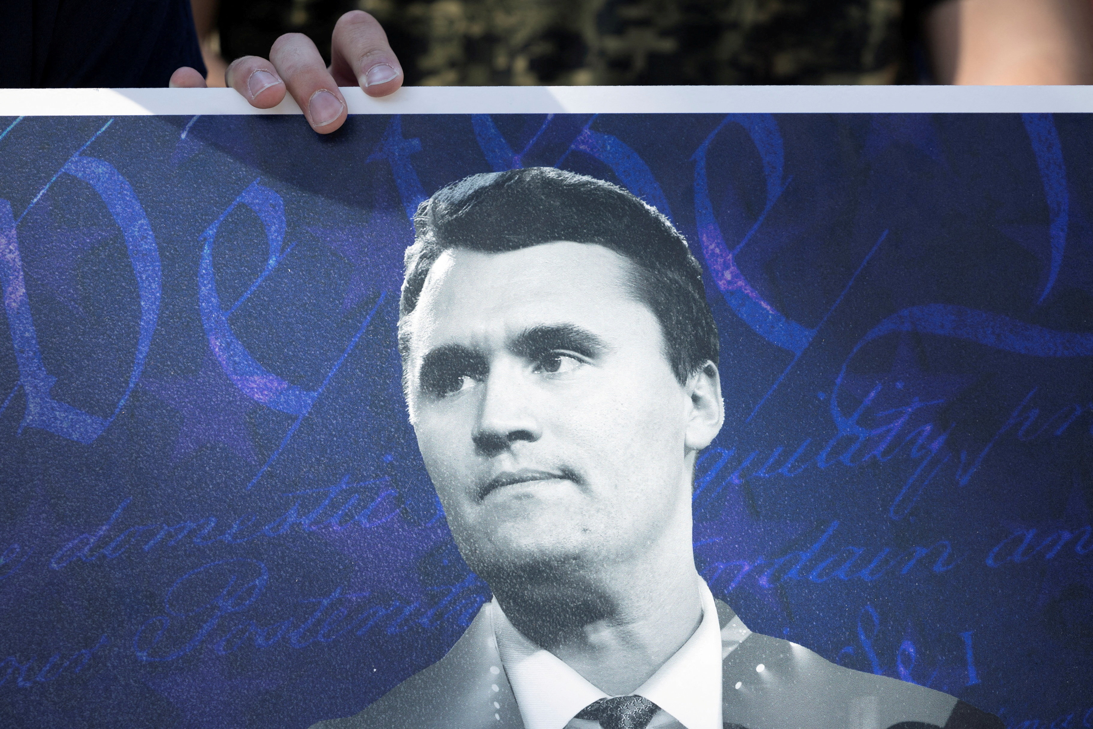 FILE PHOTO: An attendee holds a poster of conservative activist Charlie Kirk as people mourn following his fatal shooting, at the University of Houston in Houston, Texas, U.S., September 11, 2025. REUTERS/Antranik Tavitian/File Photo