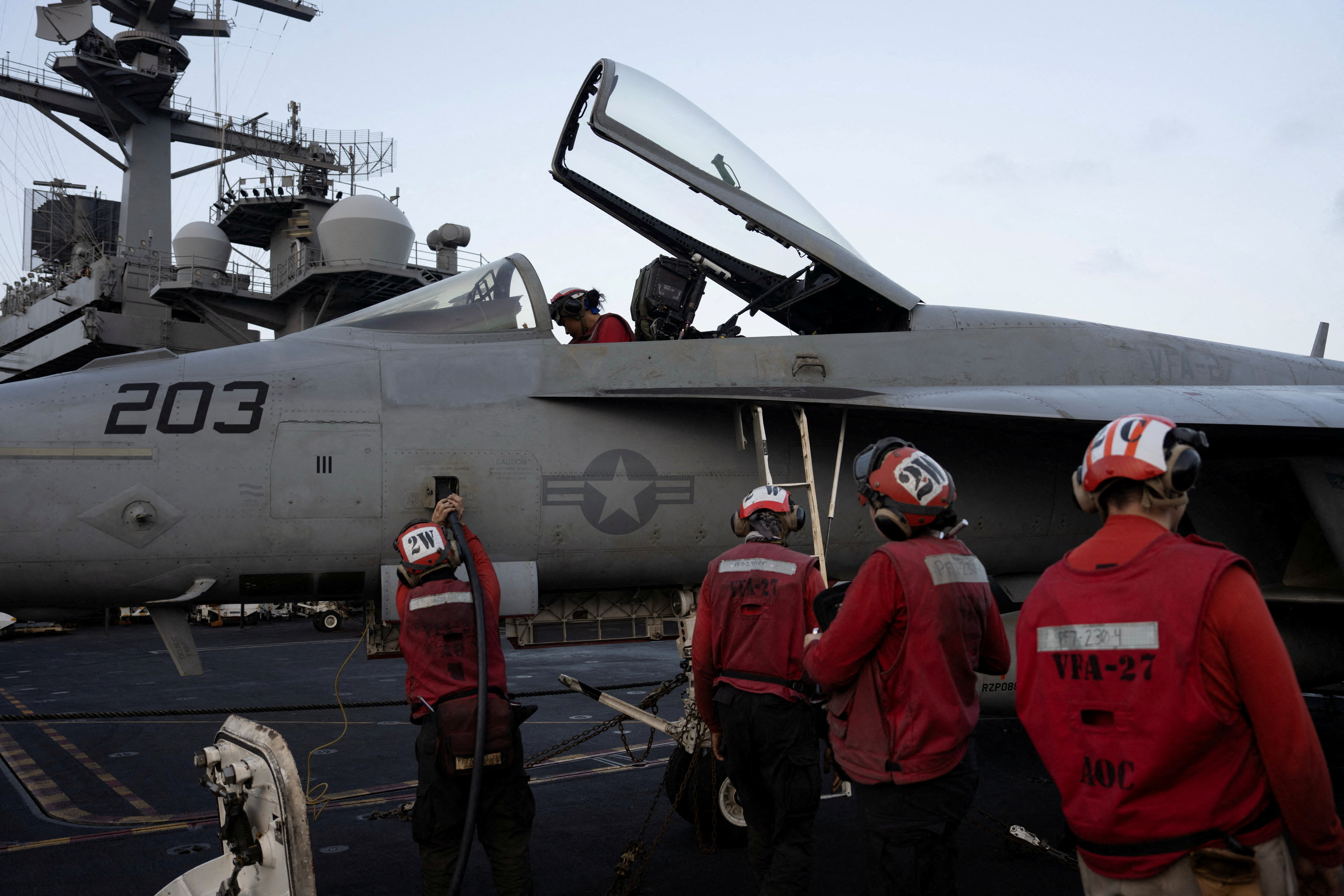 US Navy sailors tend to a fighter jet on the flight deck of the USS George Washington in the Arabian Sea on September 11, 2026. [Ed Ou/Reuters]