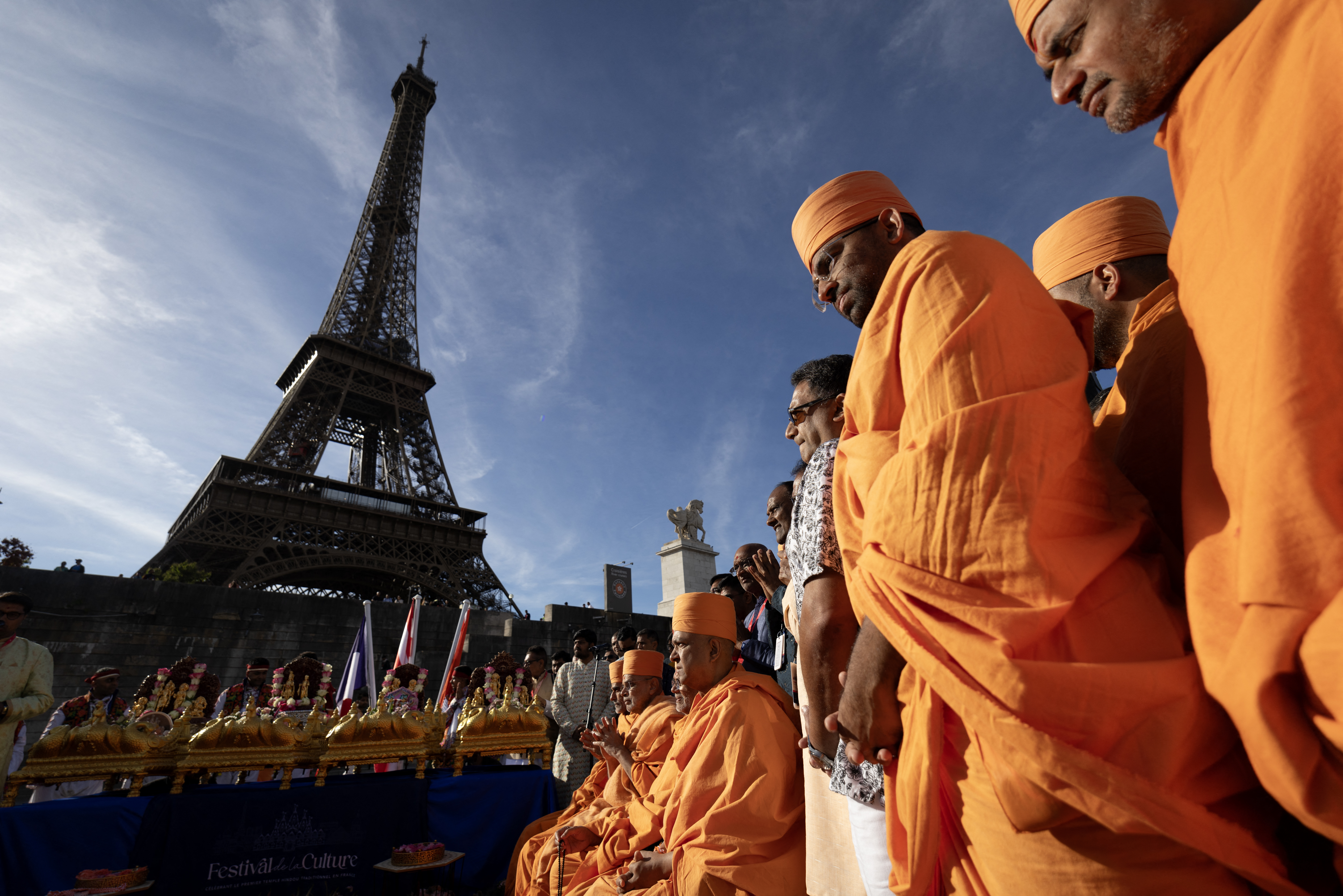 Hindu monks take part in a religious ceremony in front of the Eiffel Tower.