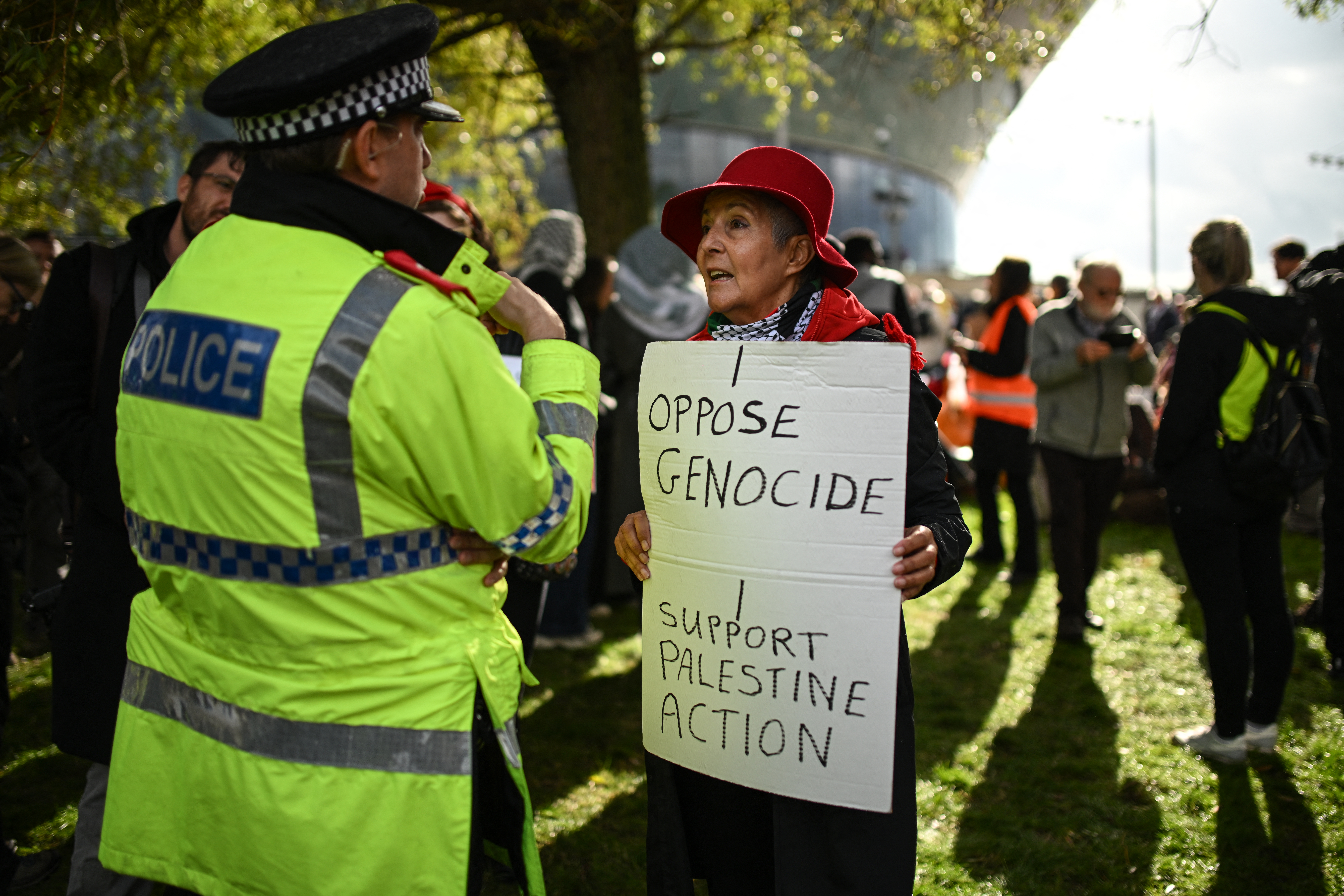A policeman speaks to a supporter of the proscribed group Palestine Action as they gather to protest outside the conference venue on the first day of the annual Labour Party conference in Liverpool, north-west England on September 27, 2026 [Oli Scarff/AFP]