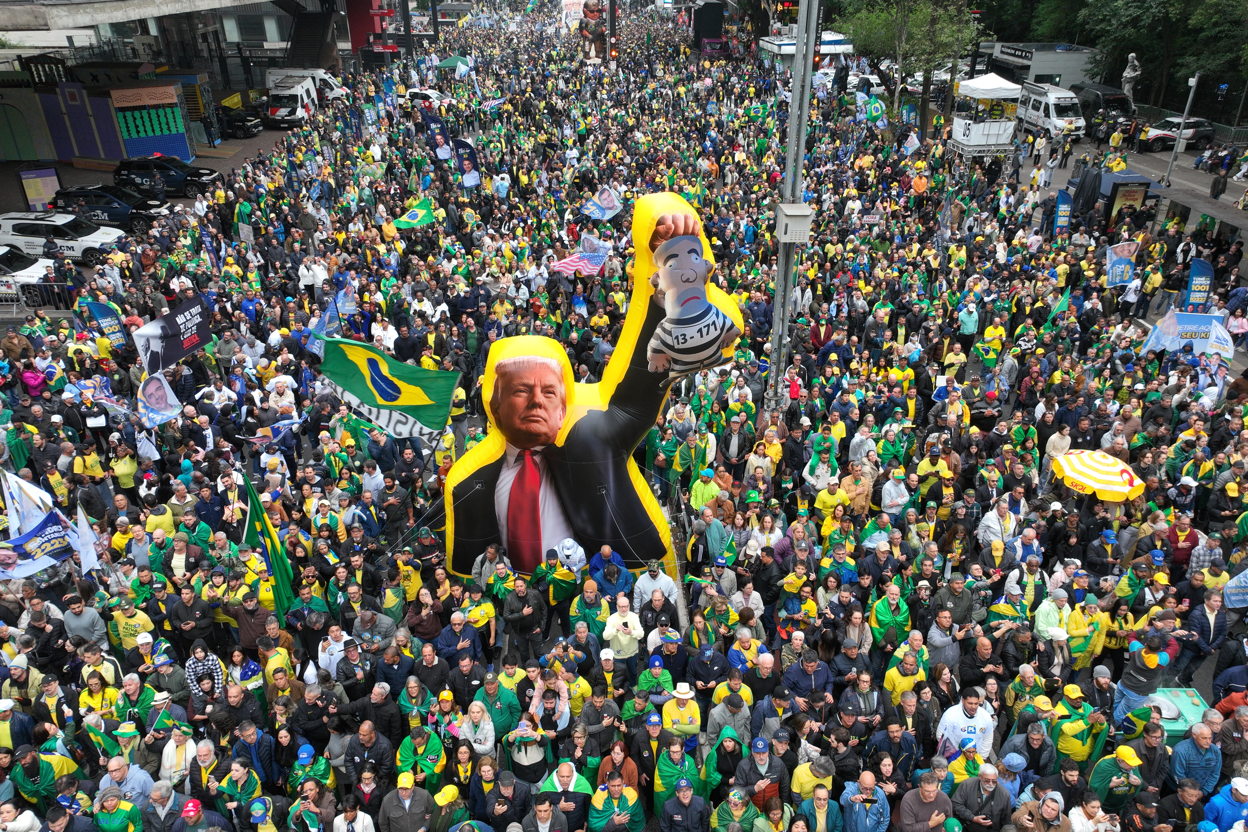 Supporters of opposition presidential candidate Flavio Bolsonaro march with an effigy of U.S. President Donald Trump holding a doll depicting Brazilian President Luiz Inacio Lula da Silva as a prisoner, during an Independence Day event in Sao Paulo, Brazil, Monday, Sept. 7, 2026, the month before the general election. (AP Photo/Andre Penner)