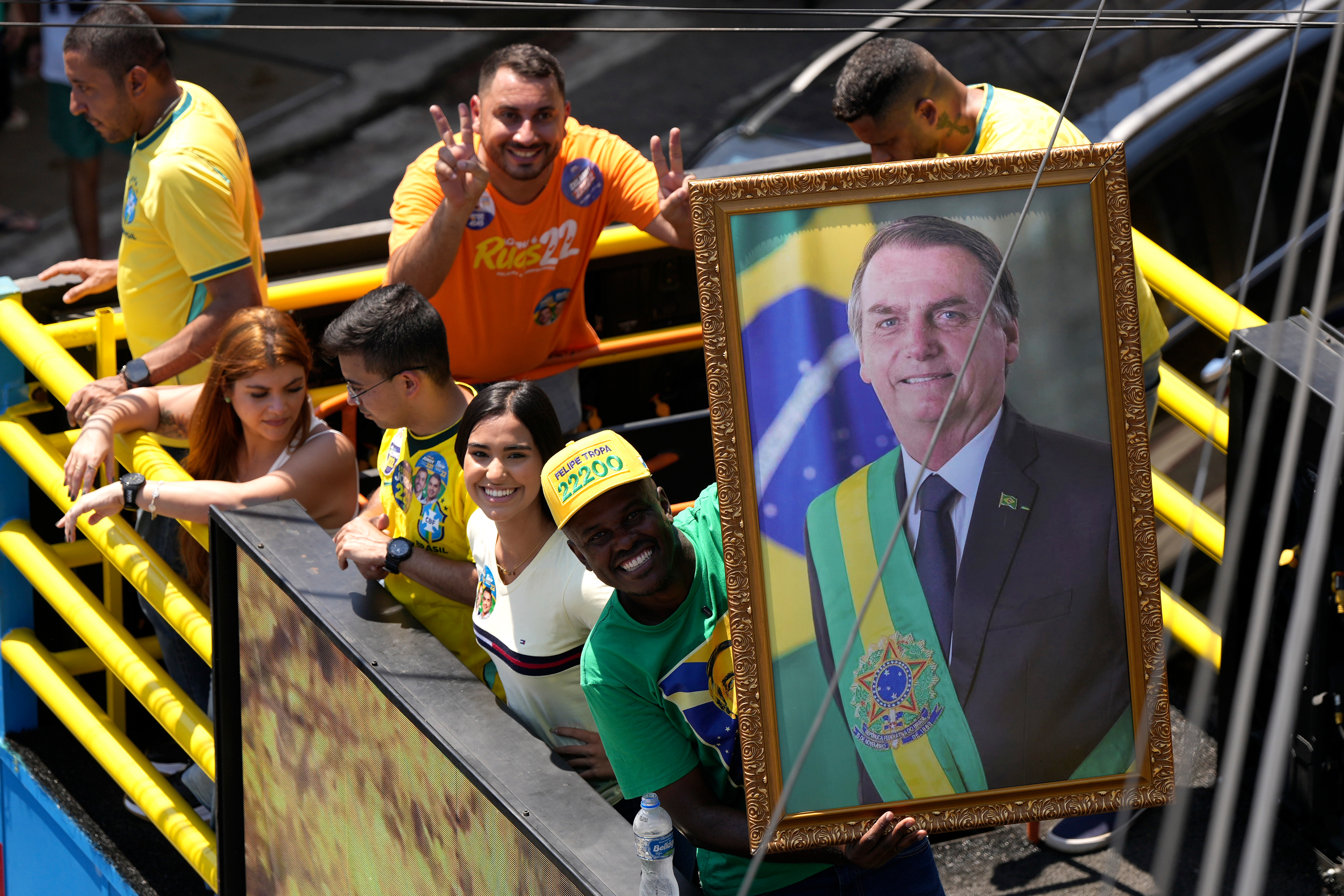 Supporters of Brazilian presidential candidate Sen. Flavio Bolsonaro ride with a framed image of his father, former President Jair Bolsonaro, during a campaign rally in Rio de Janeiro, Brazil, Saturday, Sept. 26, 2026. (AP Photo/Silvia Izquierdo)