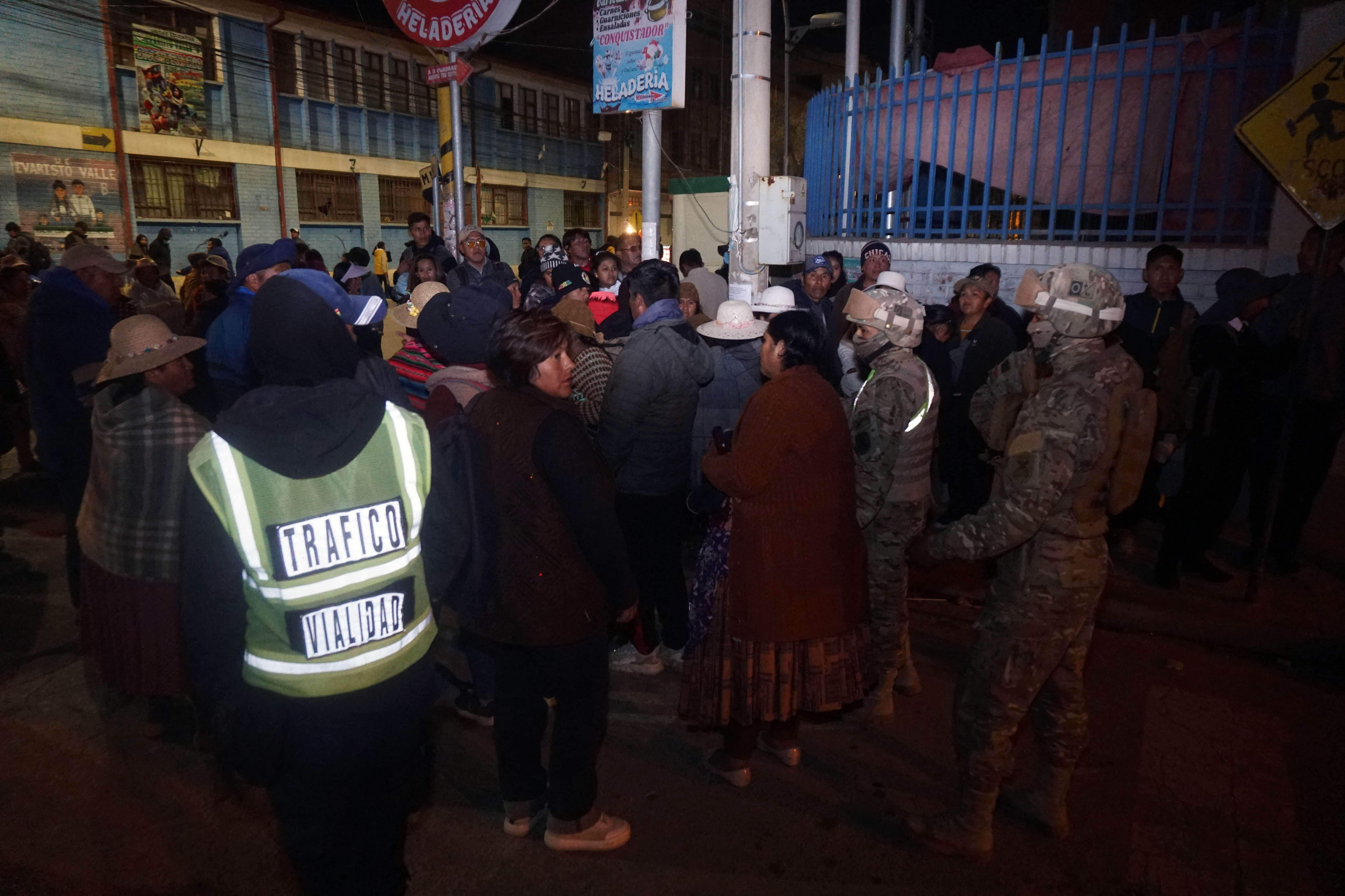 Military personnel evacuating civilians near the site of an explosion at an army barracks in Viacha. [AFP]