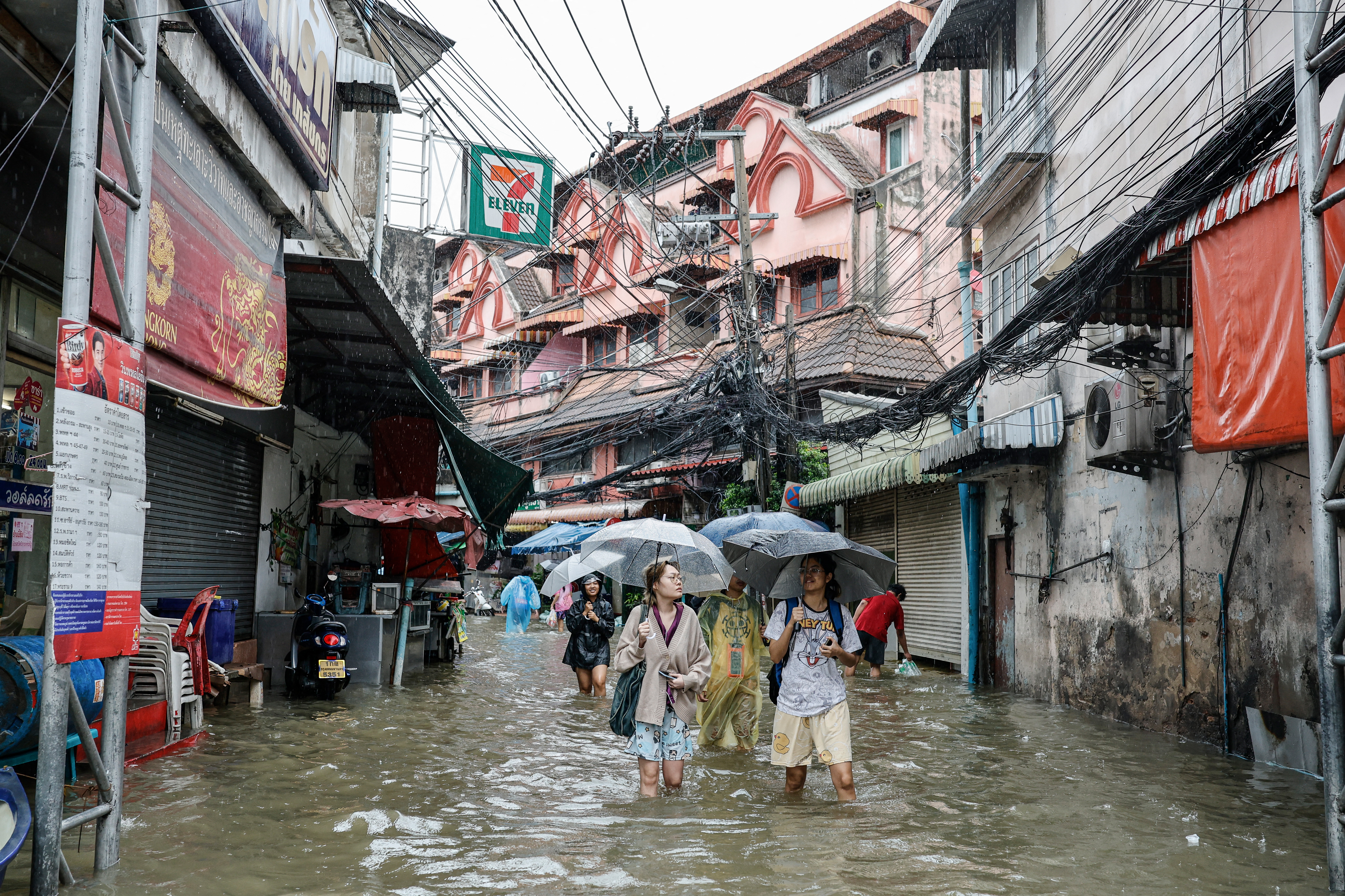 People wade through floodwaters in the Bang Bua district of Bangkok on September 26, 2026.
