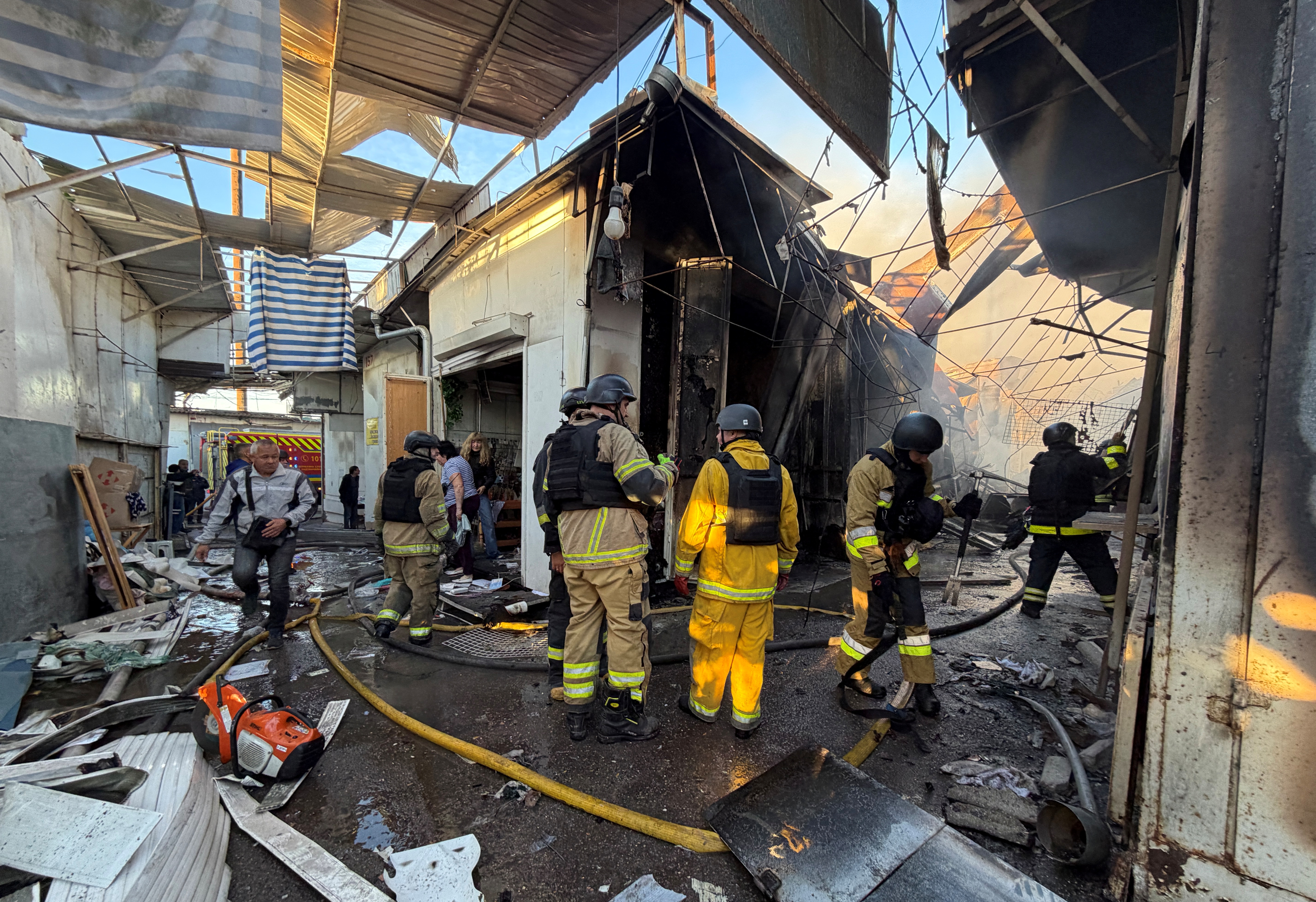 Ukrainian firefighters inspect the damage at a local market following a Russian drone strike in Zaporizhzhia on September 26, 2026, amid the Russian invasion of Ukraine.