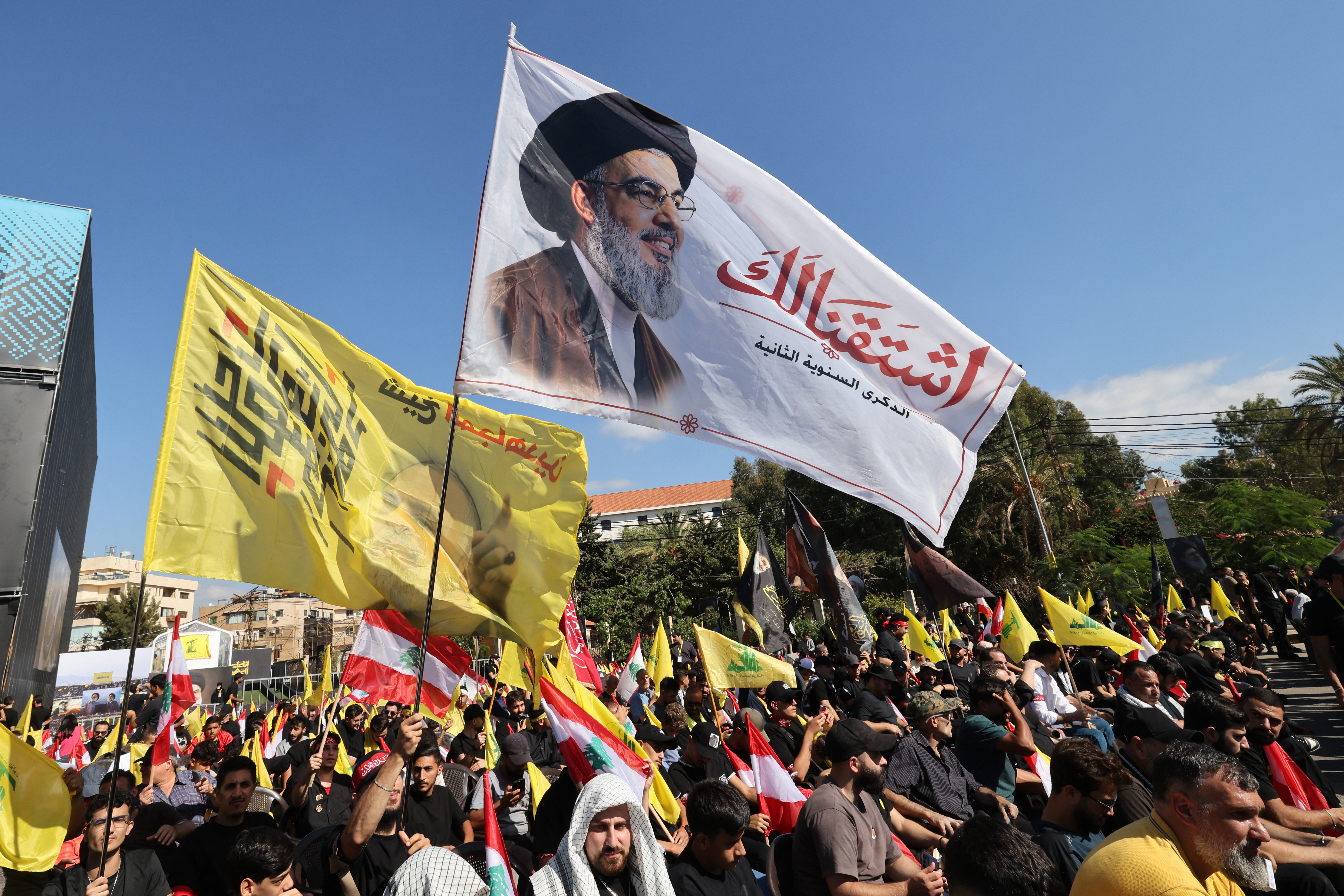 Supporters of Lebanese Shia movement Hezbollah hold up a flag bearing the image of slain leader Hassan Nasrallah during a ceremony held to mark the second anniversary of Nasrallah's killing in a strike by Israel, in Beirut's southern suburbs on September 27, 2026.