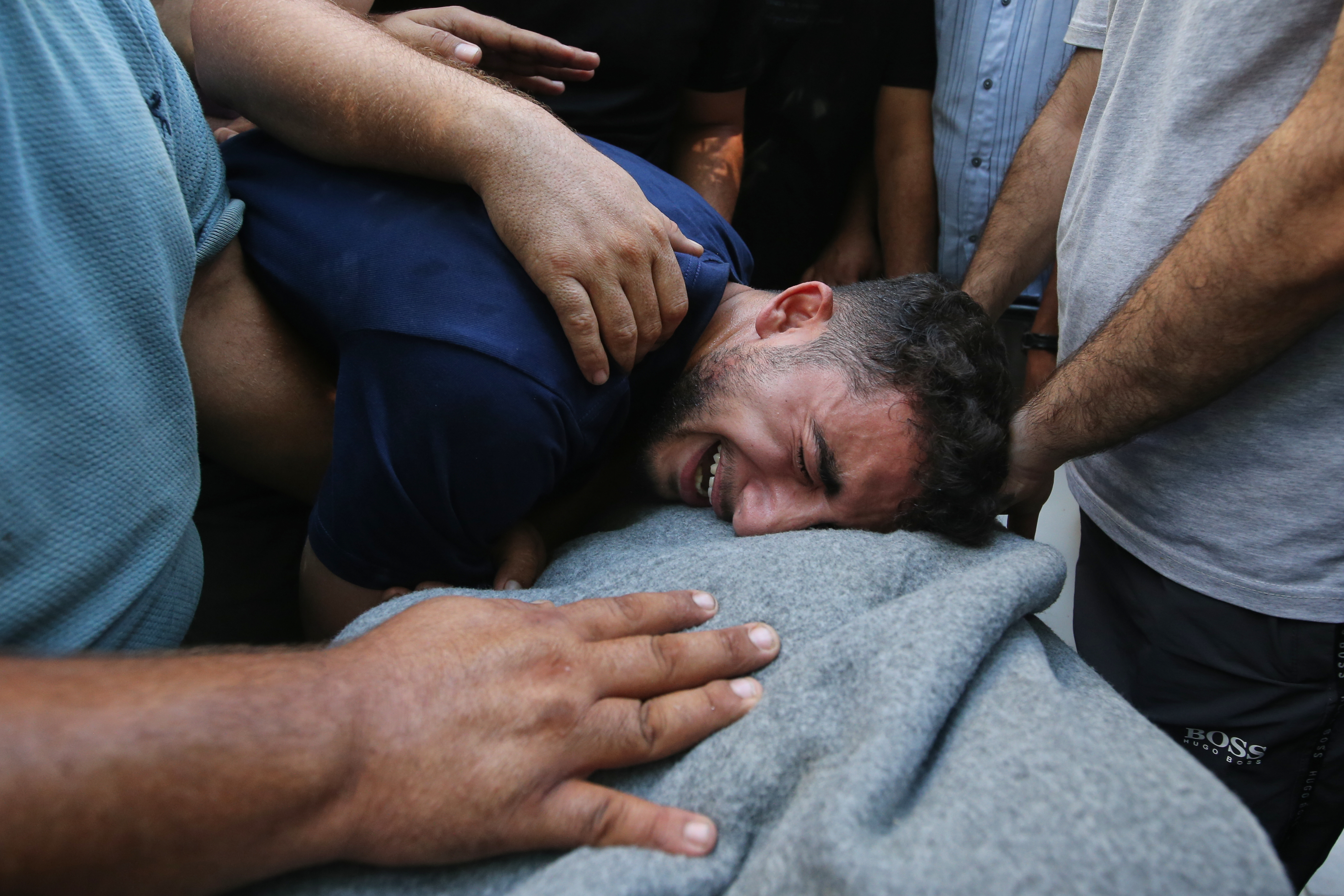 Mourners cry over the body of Palestinian Bassir al Barsh, who was killed in an Israeli airstrike, at a hospital in Gaza city, Saturday, Sept. 19, 2026. (AP Photo/Yousef Al Zanoun)
