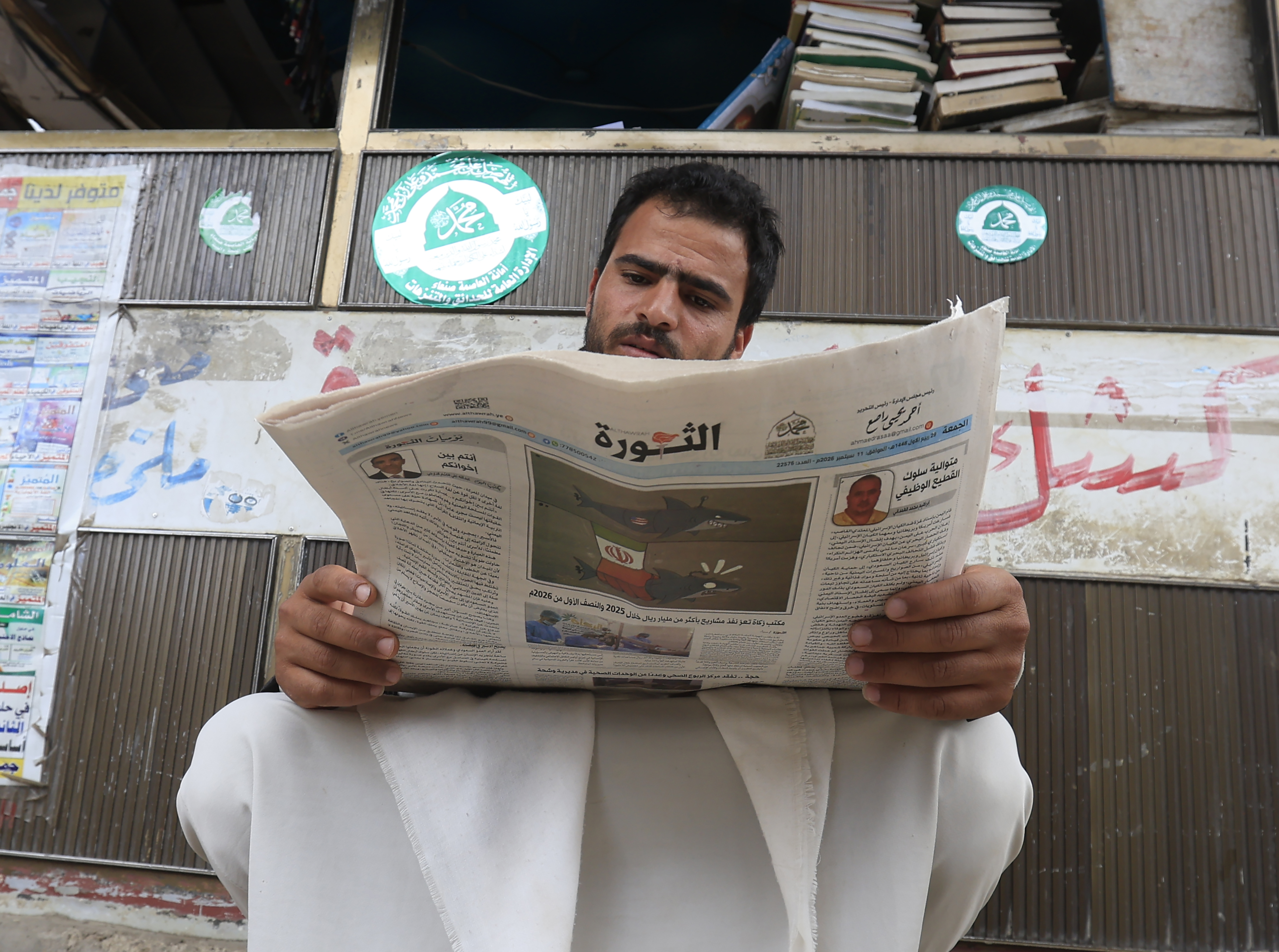 epa13232213 A person reads a local newspaper featuring news of the escalating fighting in the country, in Sana'a, Yemen, 11 September 2026. Yemen's Houthi group said navigation in the Red Sea and Bab el-Mandeb Strait remained safe except for Saudi vessels, which it says remain subject to a blockade, after seizing the port city of Mocha on 10 September and making further gains around the strategic strait on 11 September. EPA/YAHYA ARHAB