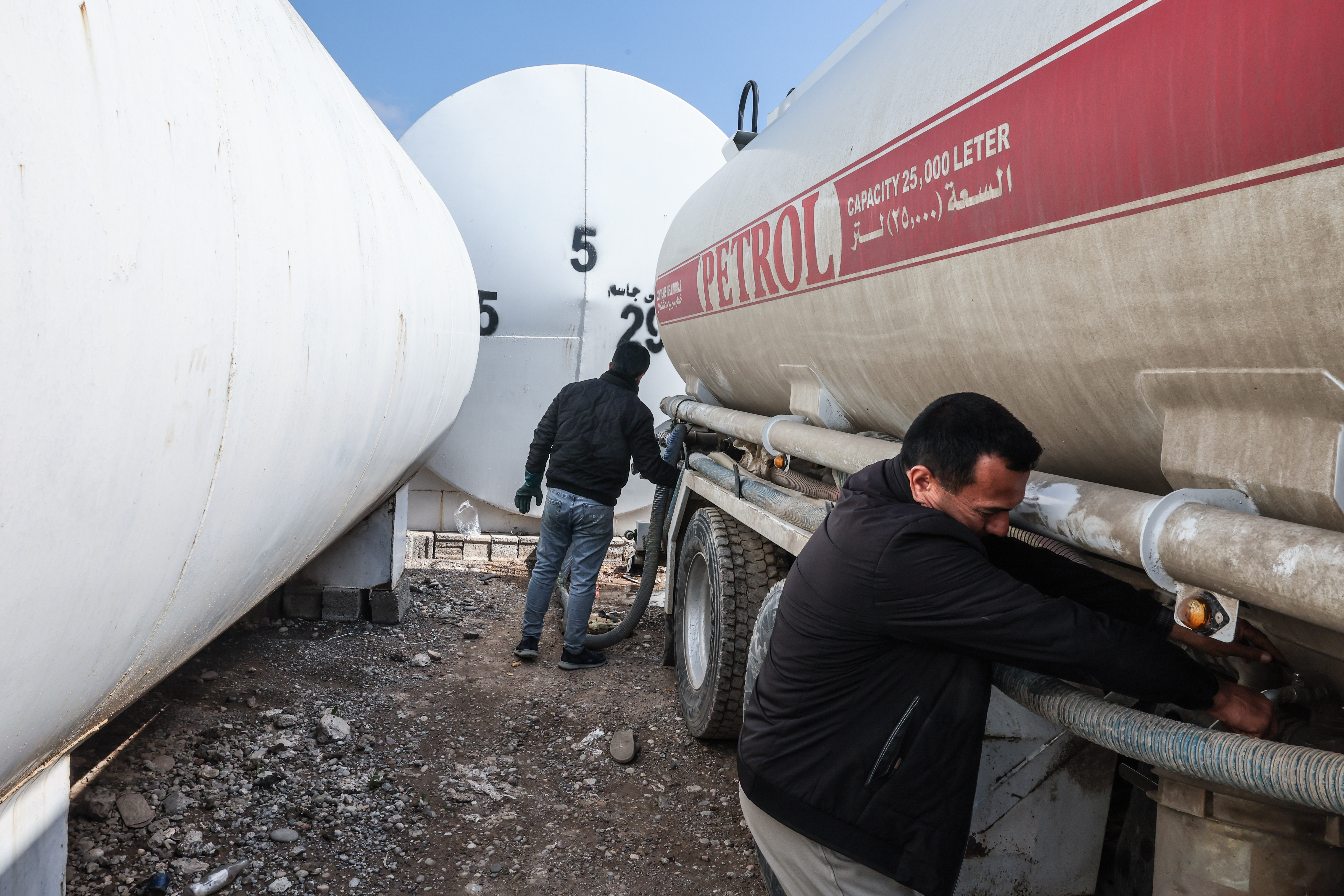 ERBIL, IRAQ - MARCH 17: Men stand near tank trucks at a market for fuel oil and automotive fuel on March 17, 2026 in Erbil, Iraq. Recent drone attacks in the region have forced some oil refineries here to cease operation, while others continue. More broadly, Iraq, a member of OPEC, has had to sharply reduce oil production as its main export route, through the Strait of Hormuz, has been block due to the war between Iran and the U.S., Israel and their regional allies. On March 12, two oil tankers were attacked in Iraqi waters offshore from its main port of Basrah, allegedly by Iranian forces. Meanwhile, Baghdad and the government of semi-autonomous Iraqi Kurdistan are negotiating to try to increase exports through the Iraq-Turkey Pipeline, which has been a source of political and legal tension. (Photo by Sedat Suna/Getty Images)