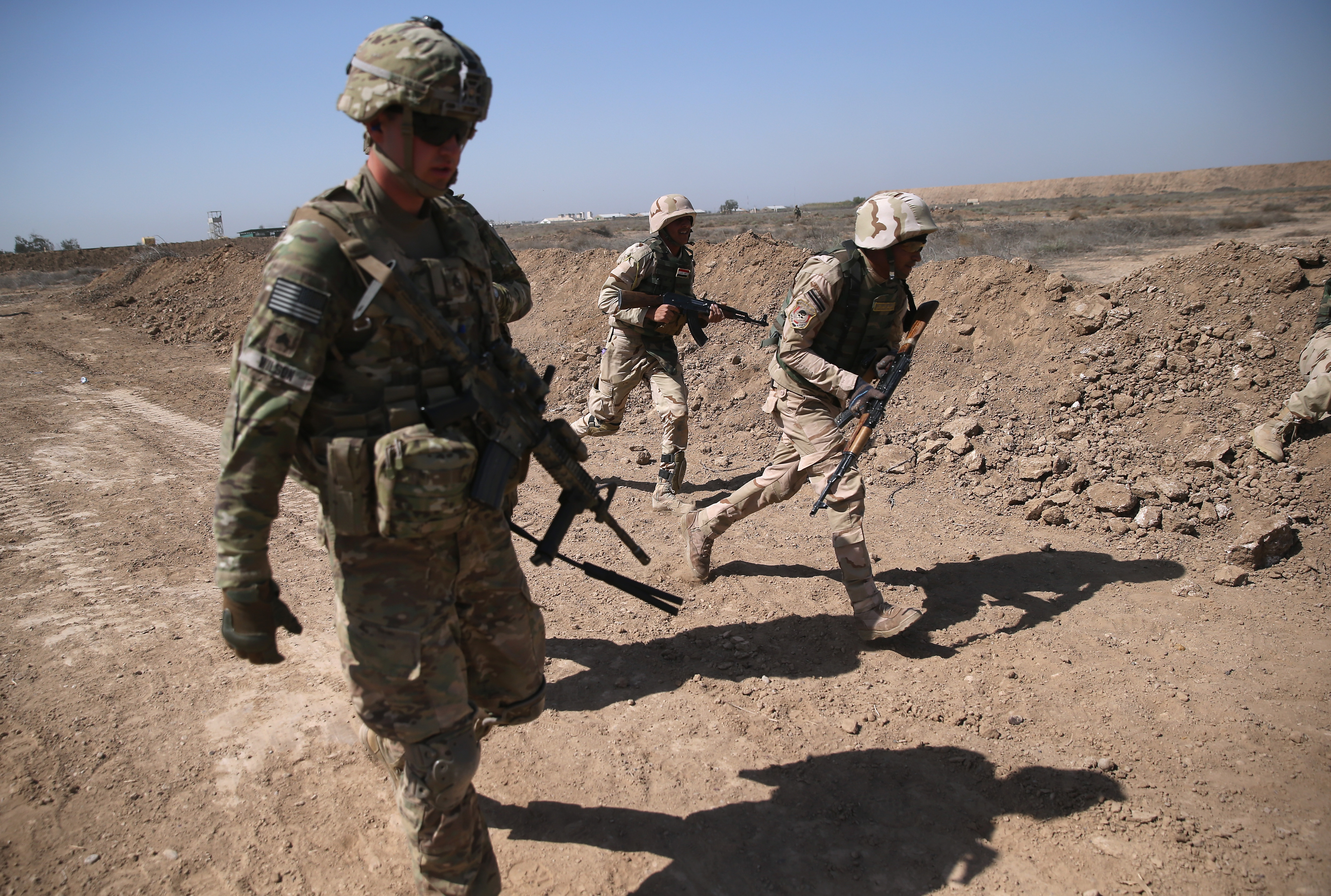 TAJI, IRAQ - APRIL 12: A U.S. Army trainer (L), instructs Iraqi Army recruits at a military base on April 12, 2015 in Taji, Iraq. U.S. forces, currently operating in 5 large bases throught Iraq, are training thousands of Iraqi Army combat troops, trying to rebuild a force they had origninally trained before the U.S. withdrawal from Iraq in 2010. Members of the U.S. Army's 5-73 CAV, 3BCT, 82nd Airborne Division are teaching members of the newly-formed 15th Division of the Iraqi Army, as the Iraqi government launches offensives to try to recover territory lost to ISIS last year. (Photo by John Moore/Getty Images)