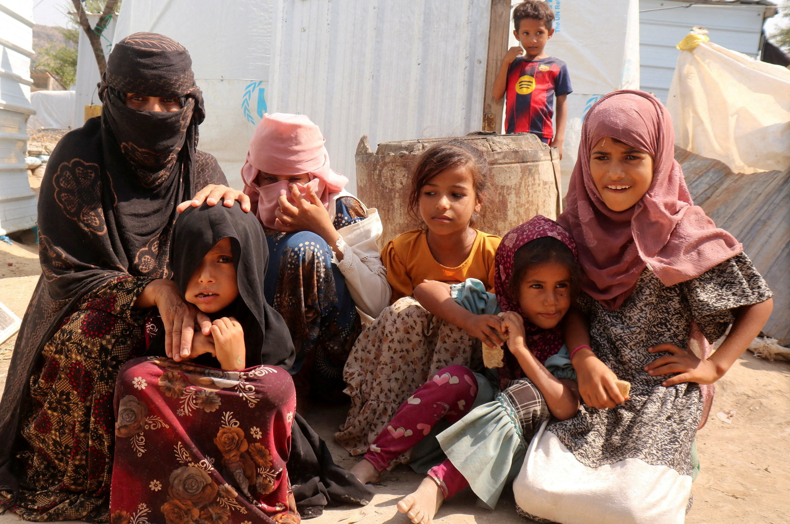 Rawya Hassan, a mother of seven, sits with her children outside their hut at the al-Bireen camp for displaced people who fled fighting between the Houthis and forces of Yemen's internationally recognized government in Taiz province, Yemen, September 17, 2026. REUTERS/Stringer TPX IMAGES OF THE DAY