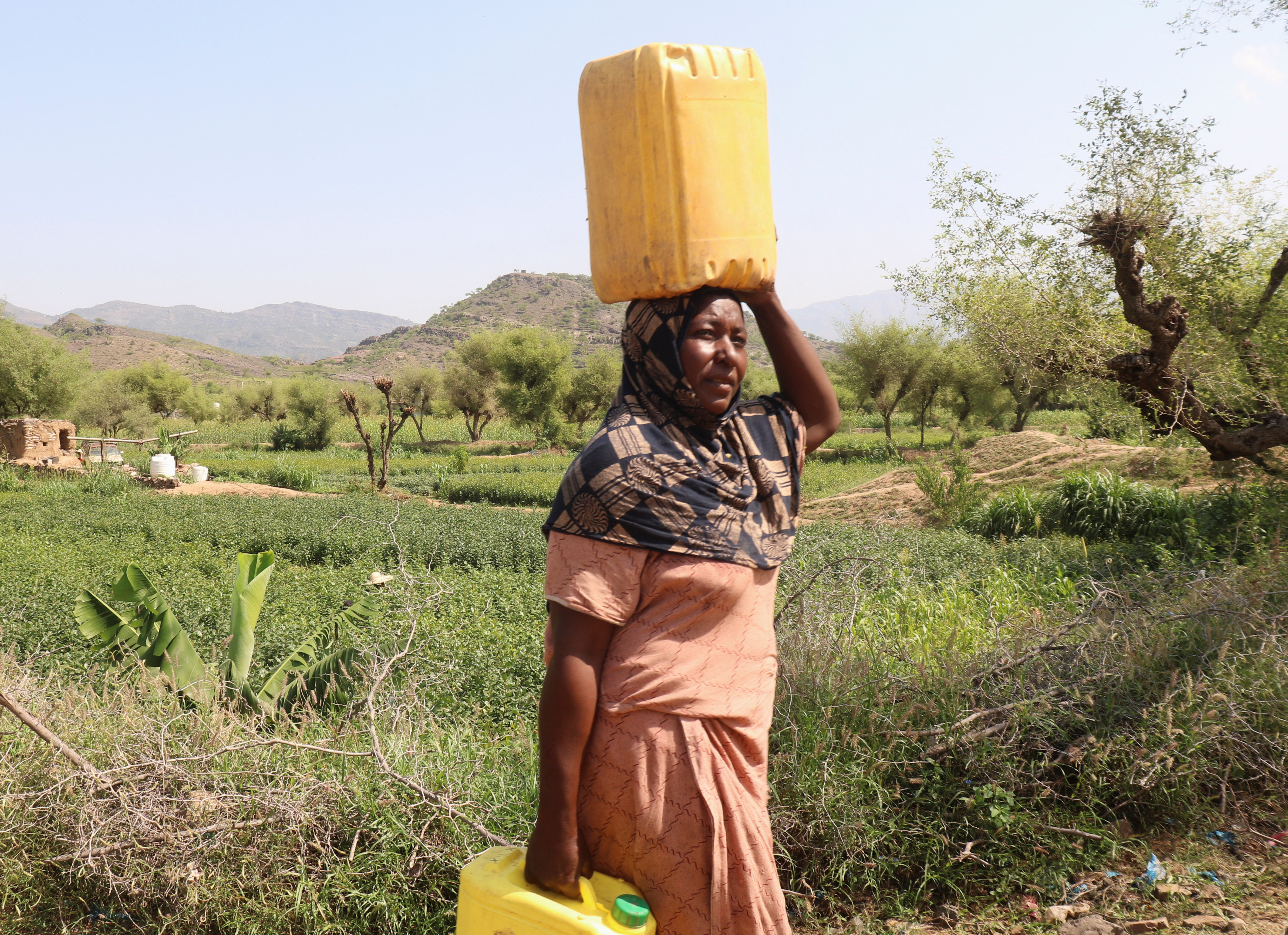 A woman carries jerry cans as she collects water for a makeshift camp for people displaced by clashes between Iran-aligned Houthi fighters and Saudi-backed Yemeni government forces, in Taiz province, Yemen, September 23, 2026. REUTERS/Ebrahim Al-Suhaibi