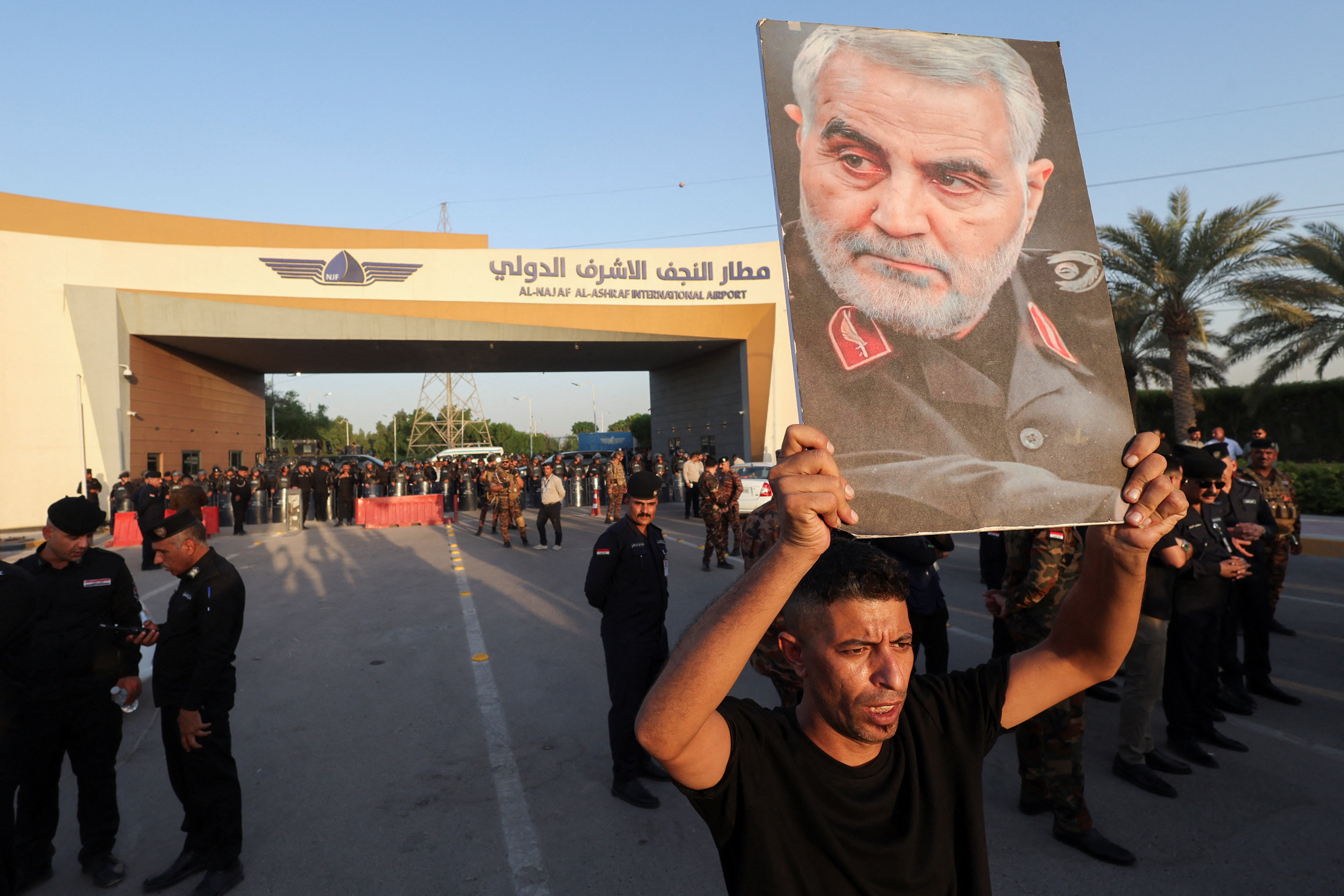 A protester holds a portrait of slain Iranian military commander Qassem Soleimani during a protest against U.S. restrictions targeting Iranian aviation activities and their impact on flights between Iran and Iraq, outside Najaf International Airport in Najaf, Iraq, September 28, 2026. REUTERS/Alaa Al-Marjani