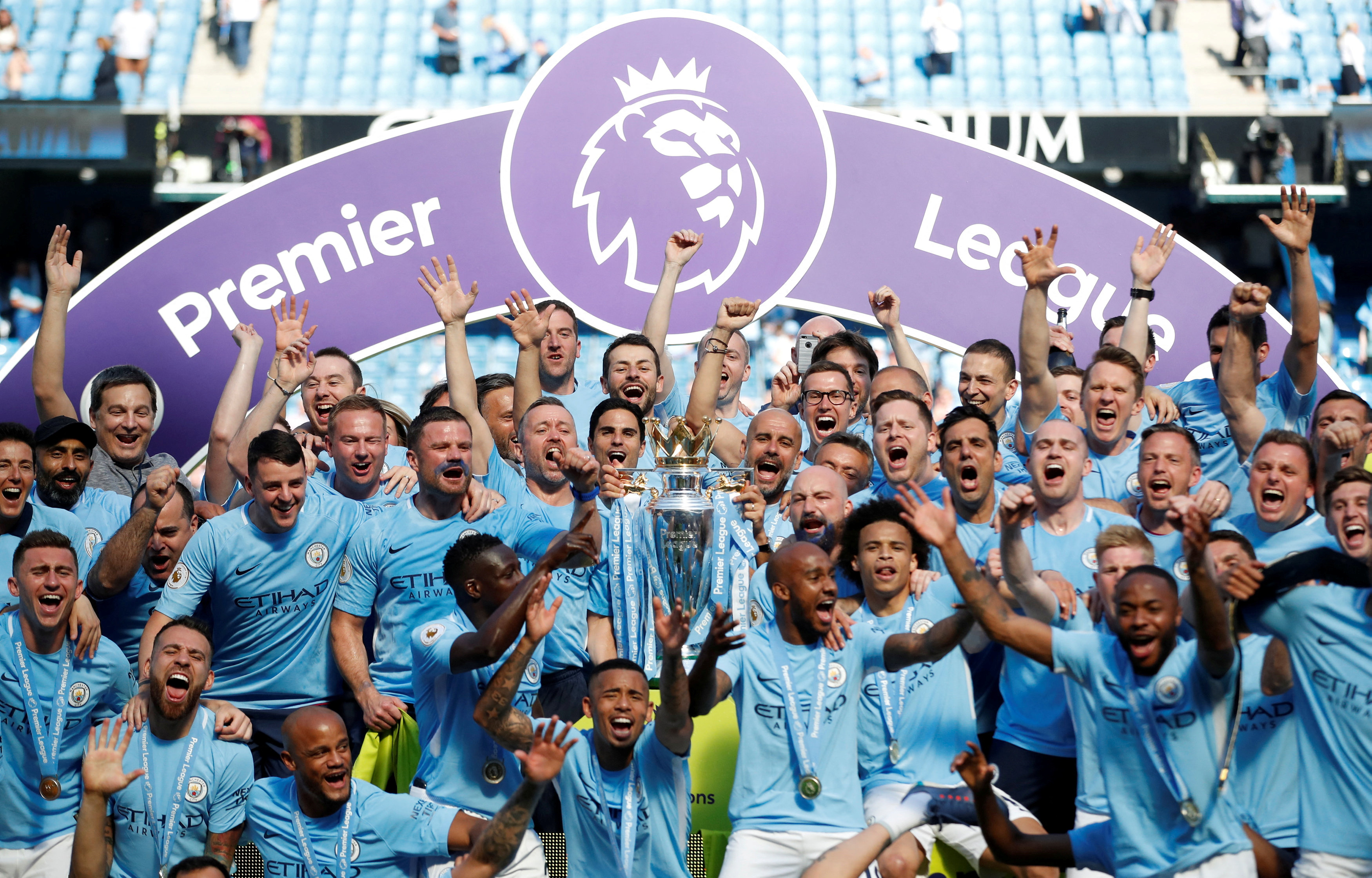 FILE PHOTO: Soccer Football - Premier League - Manchester City vs Huddersfield Town - Etihad Stadium, Manchester, Britain - May 6, 2018 Manchester City manager Pep Guardiola celebrates with the trophy, players and staff after winning the Premier League title Action Images via Reuters/Carl Recine EDITORIAL USE ONLY. No use with unauthorized audio, video, data, fixture lists, club/league logos or "live" services. Online in-match use limited to 75 images, no video emulation. No use in betting, games or single club/league/player publications. Please contact your account representative for further details./File Photo