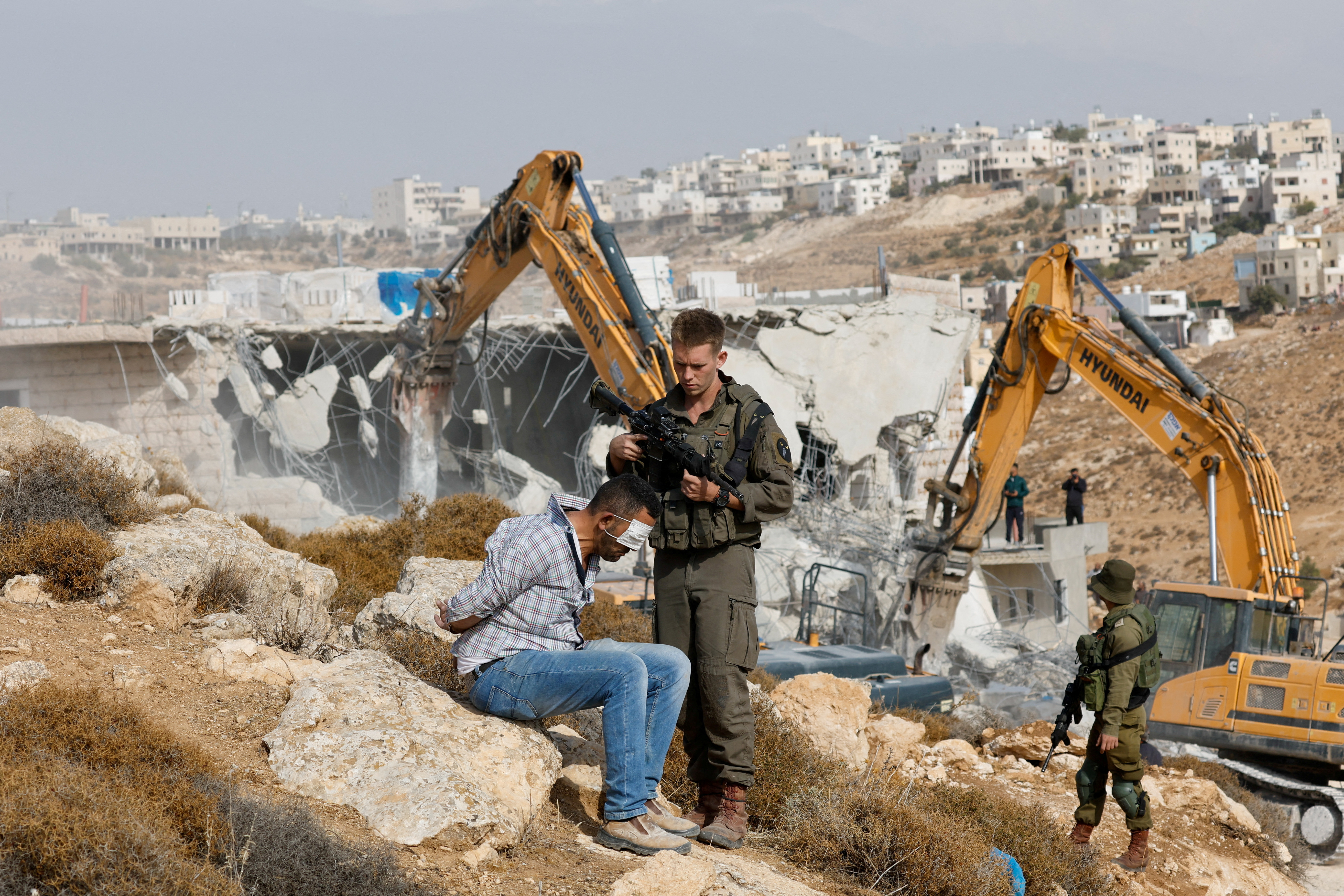 An Israeli soldier detains a Palestinian man during clashes following the demolishing of a Palestinian house in Hebron, in the Israeli-occupied West Bank October 25, 2022. REUTERS/Mussa Qawasma TPX IMAGES OF THE DAY