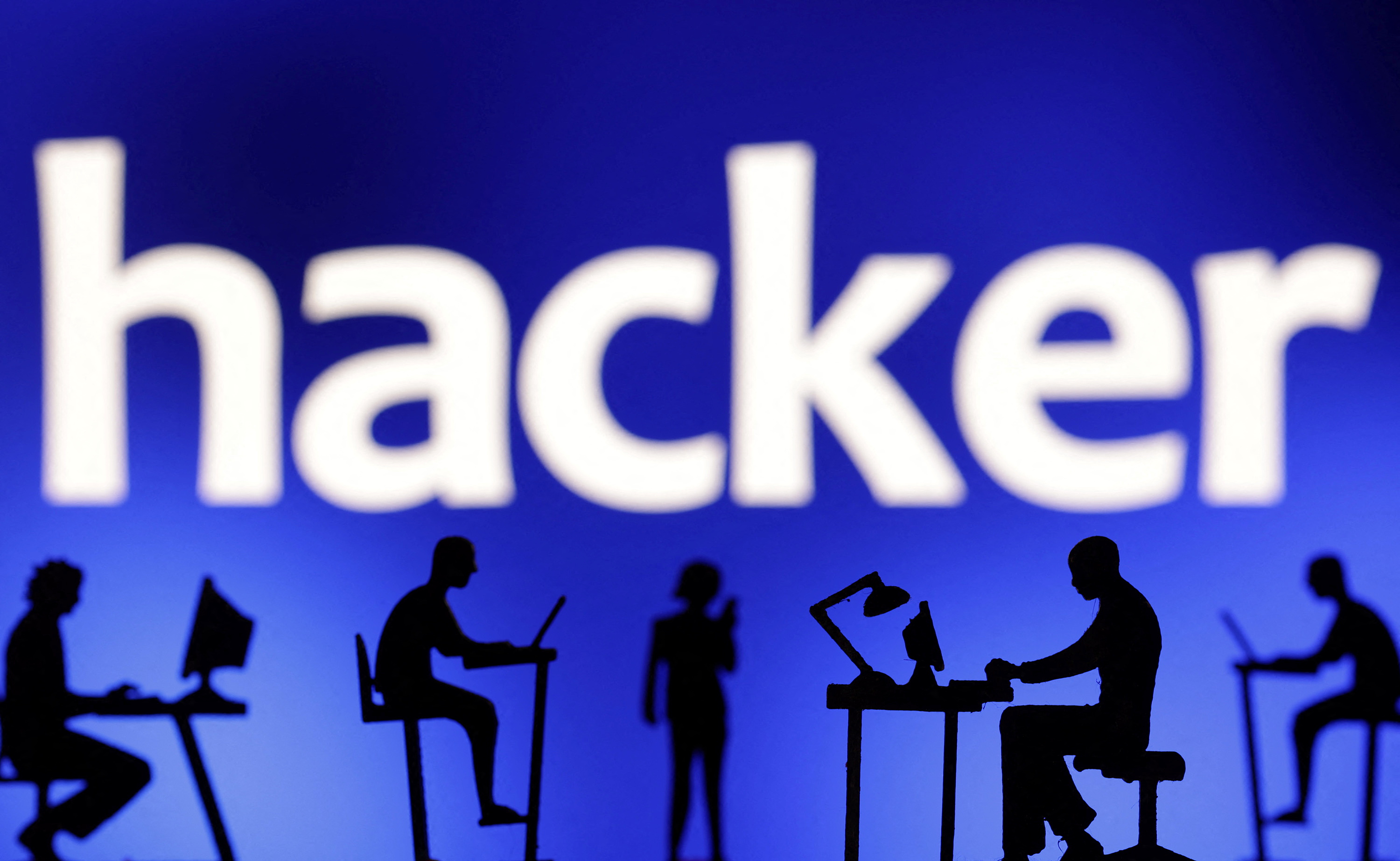 Figurines with computers and smartphones are seen in front of the word "hacker" in this illustration taken, February 19, 2024. REUTERS/Dado Ruvic/Illustration