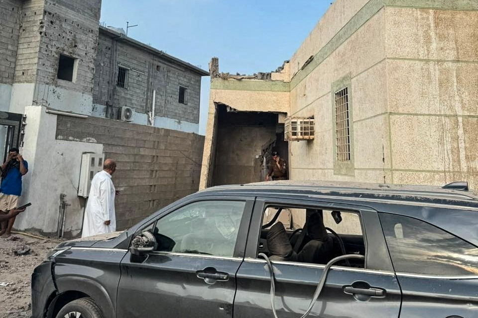 People inspect a damaged vehicle.