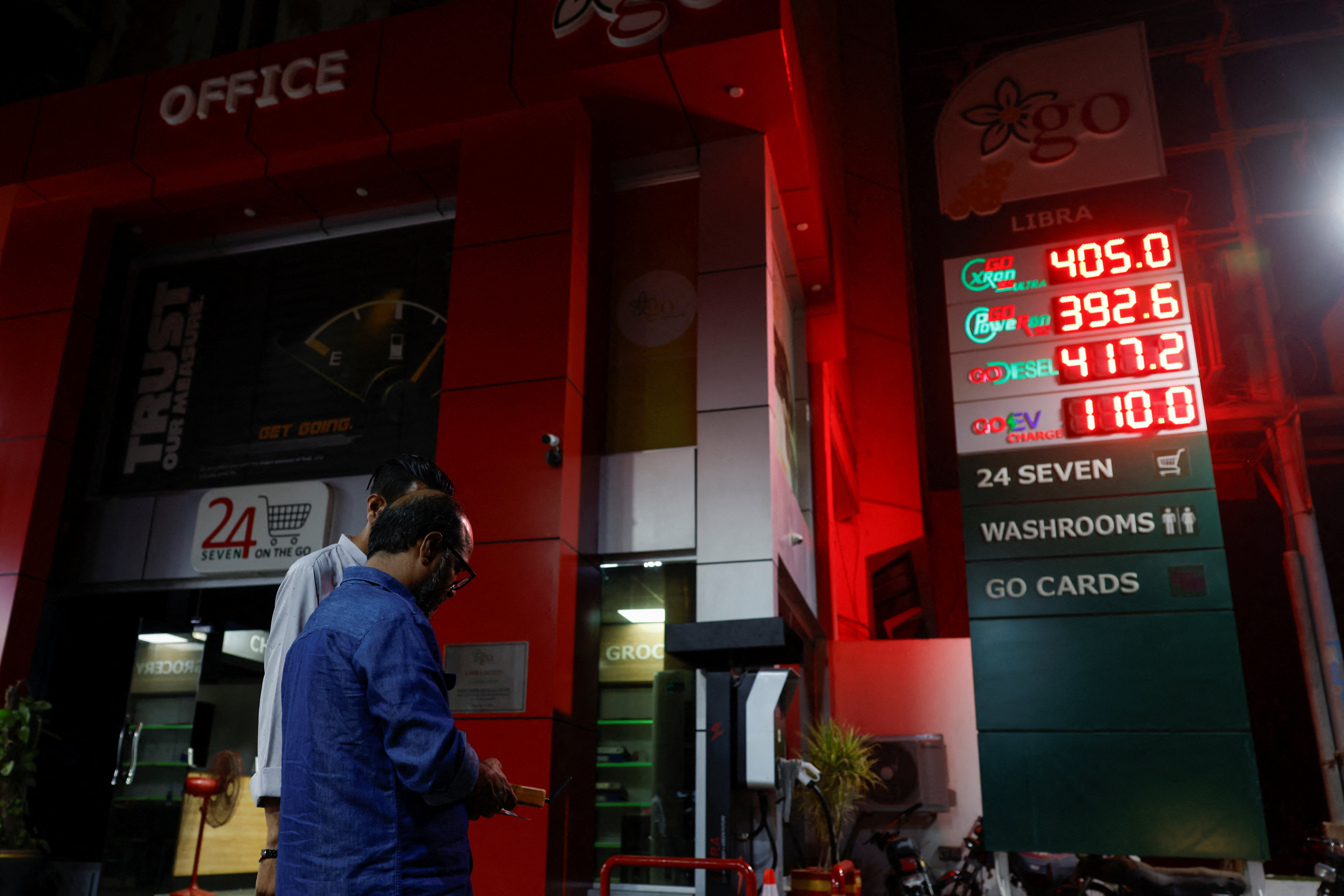 Workers use a device to update the price displayed on a board at a petrol station following the rollout of a fuel relief scheme, which provides a fuel subsidy for eligible motorcycles, rickshaws and vehicles with engines of up to 800cc, in Karachi, Pakistan, September 16, 2026. [Akhtar Soomro/Reuters]