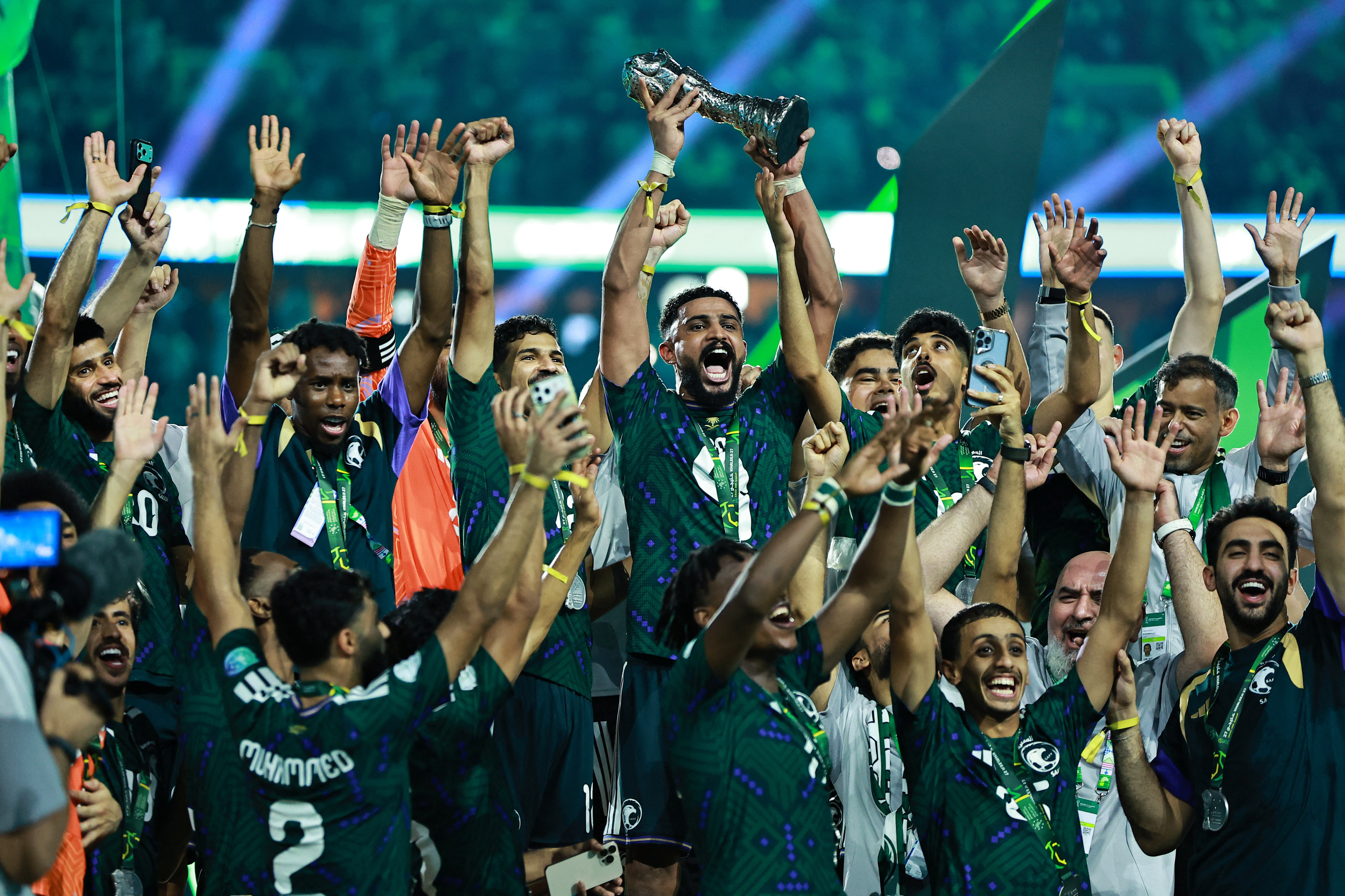 Players celebrate with the trophy.