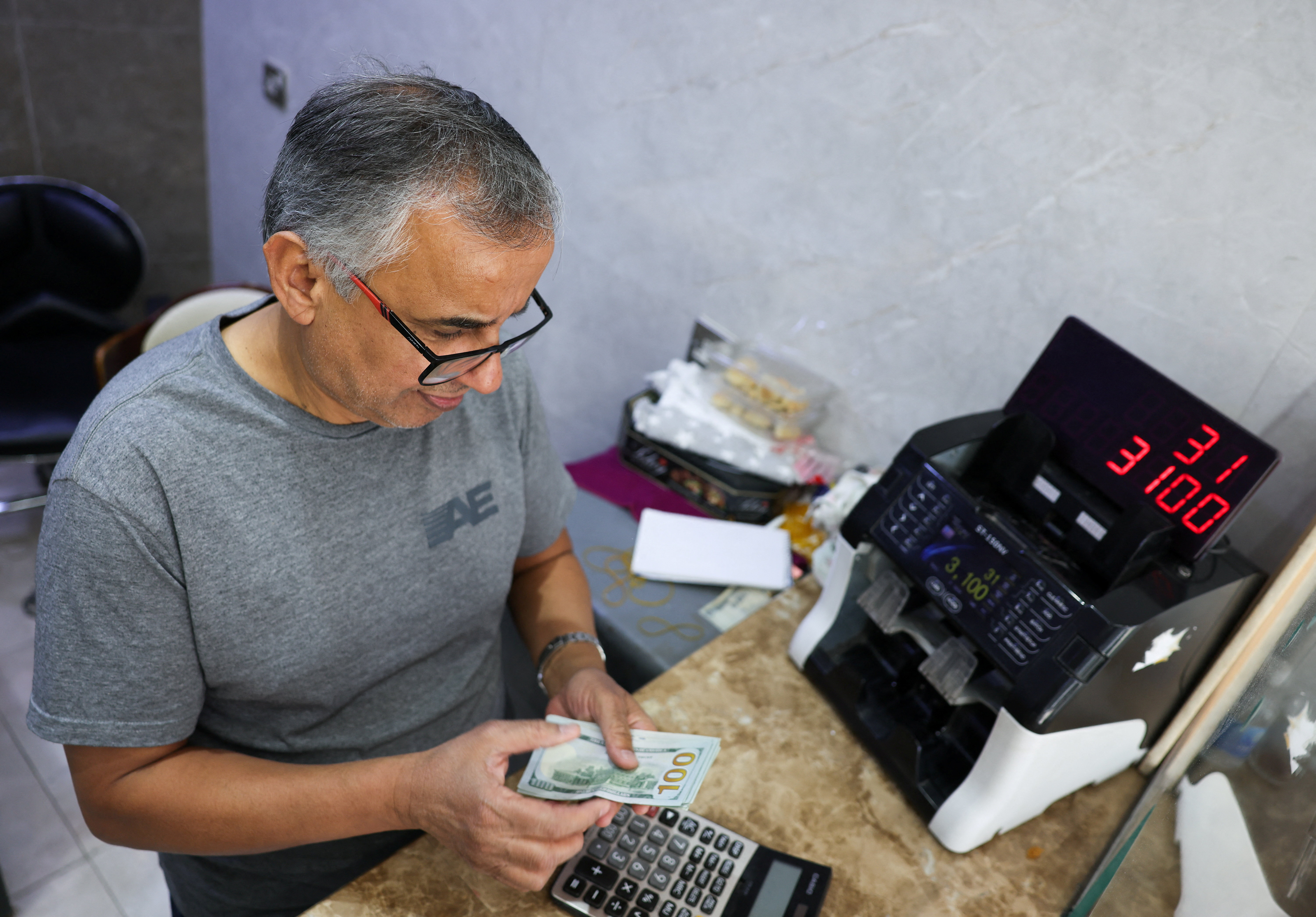 A man counts U.S. dollar banknotes at a currency exchange shop in Baghdad, Iraq, October 7, 2026 [Ahmed Saad/Reuters]