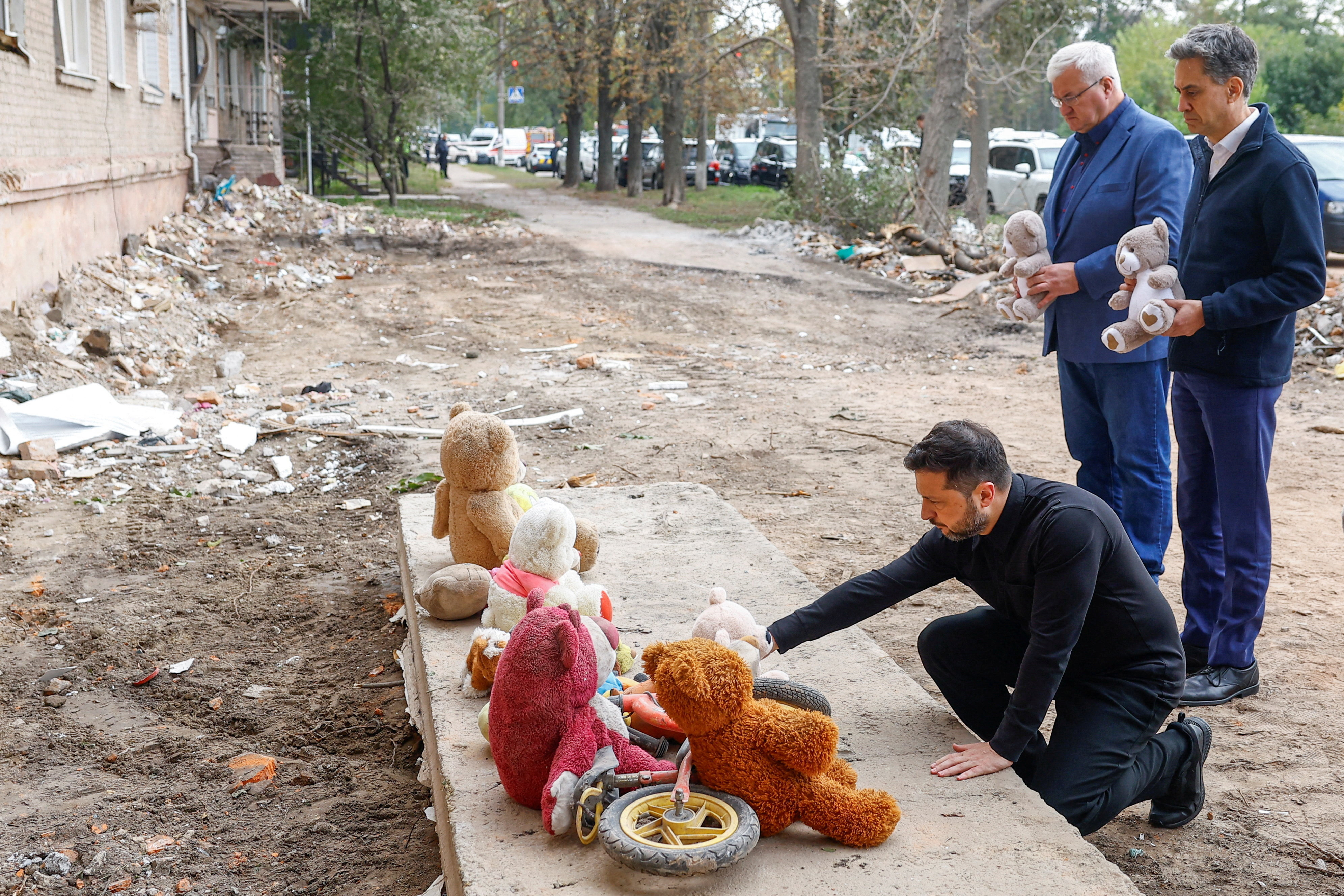 British Foreign Secretary Ed Miliband, Ukraine's President Volodymyr Zelenskiy and Foreign Minister Andrii Sybiha visit a makeshift memorial at the site of an apartment building where 22 residents were killed yesterday by a Russian missile strike in the town of Pryluky, amid Russia's attack on Ukraine, in the Chernihiv region, Ukraine, October 8, 2026. REUTERS/Valentyn Ogirenko TPX IMAGES OF THE DAY