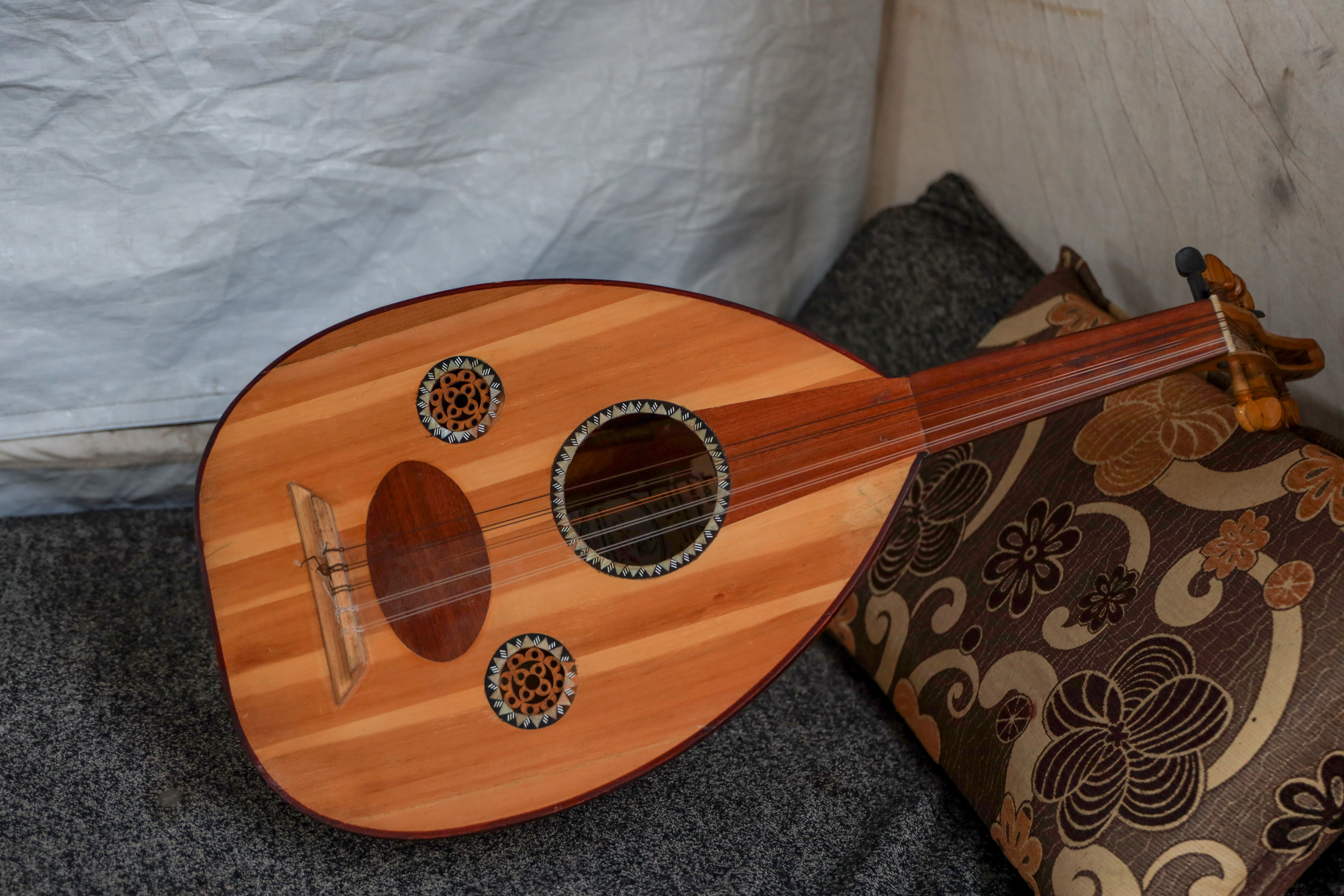 When Yaseen al-Qubt, 16, left his home in Beit Lahia on October 12, 2023, he took his oud with him. His family moved to al-Zawaida in central Gaza, while their home was later bombed and the instrument was left beneath the rubble. Yaseen had owned the oud since January 2023 and had learned to play with the help of a neighbour who was an oud player. He later managed to recover his Oud from under the ruins. He picked it up again and continued playing. “When I am sad, I play. When I am happy, I play too,” he says, describing the oud as a place where he can express what he feels. For Yaseen, playing is also a way to comfort children in the displacement camp. When the sound of drones frightens them, he plays the oud to cover the sound of fear with music and give them moments of calm. He dreams of leaving Gaza to continue studying music, playing on large stages and eventually owning a professional oud that will help him develop his skills. For now, he says, he remains attached to the instrument because “we still have something beautiful to offer.”