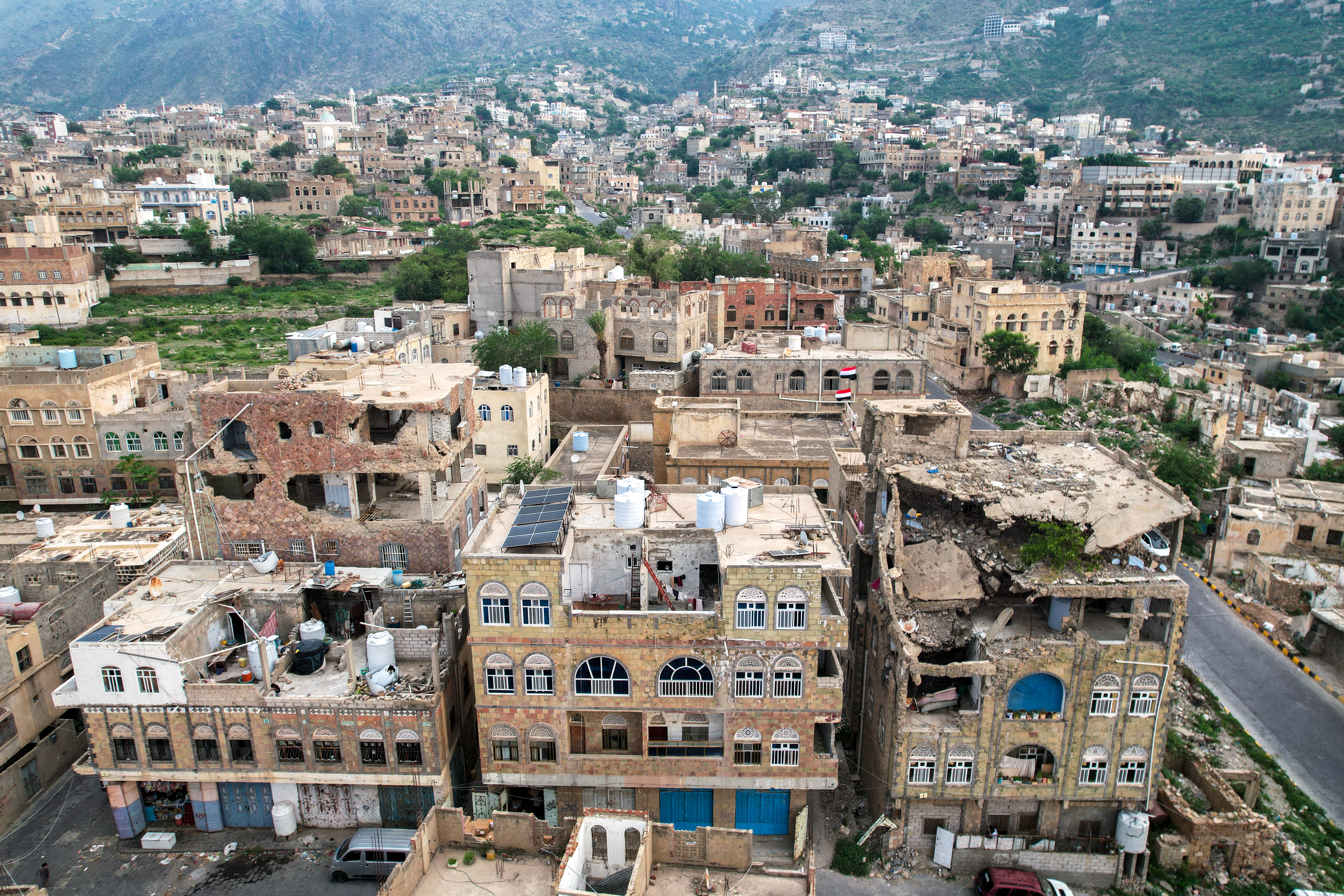 This aerial photograph taken by drone shows damaged buildings in the city of Taiz, the capital of Taiz Governorate in southwestern Yemen on September 25, 2026. The head of Yemen's governing body on September 25 called for a general mobilisation to counter the Iran-backed Houthis, as the group ramps up attacks on government forces and their Saudi backer. His call comes weeks after Yemen's fragmented government was dealt a major blow by the Houthis, who seized control of the country's entire Red Sea coast and are still fighting its forces in Yemen and attacking Saudi ships and territory. (Photo by AFP) /