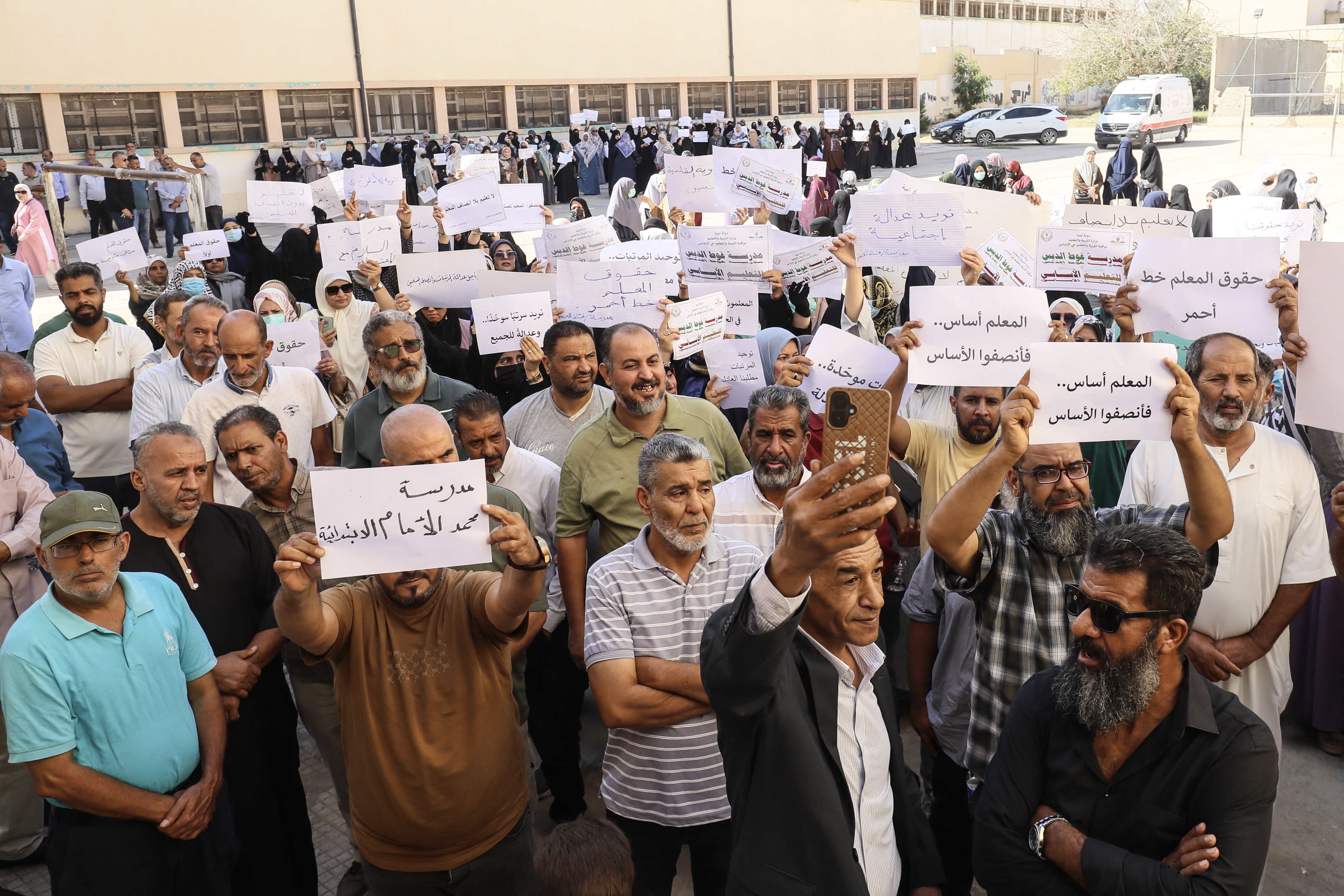 Teachers hold up placards during a demonstration demanding higher salaries and better working conditions at a school in Tripoli on September 29, 2026. (Photo by Mahmud Turkia / AFP)