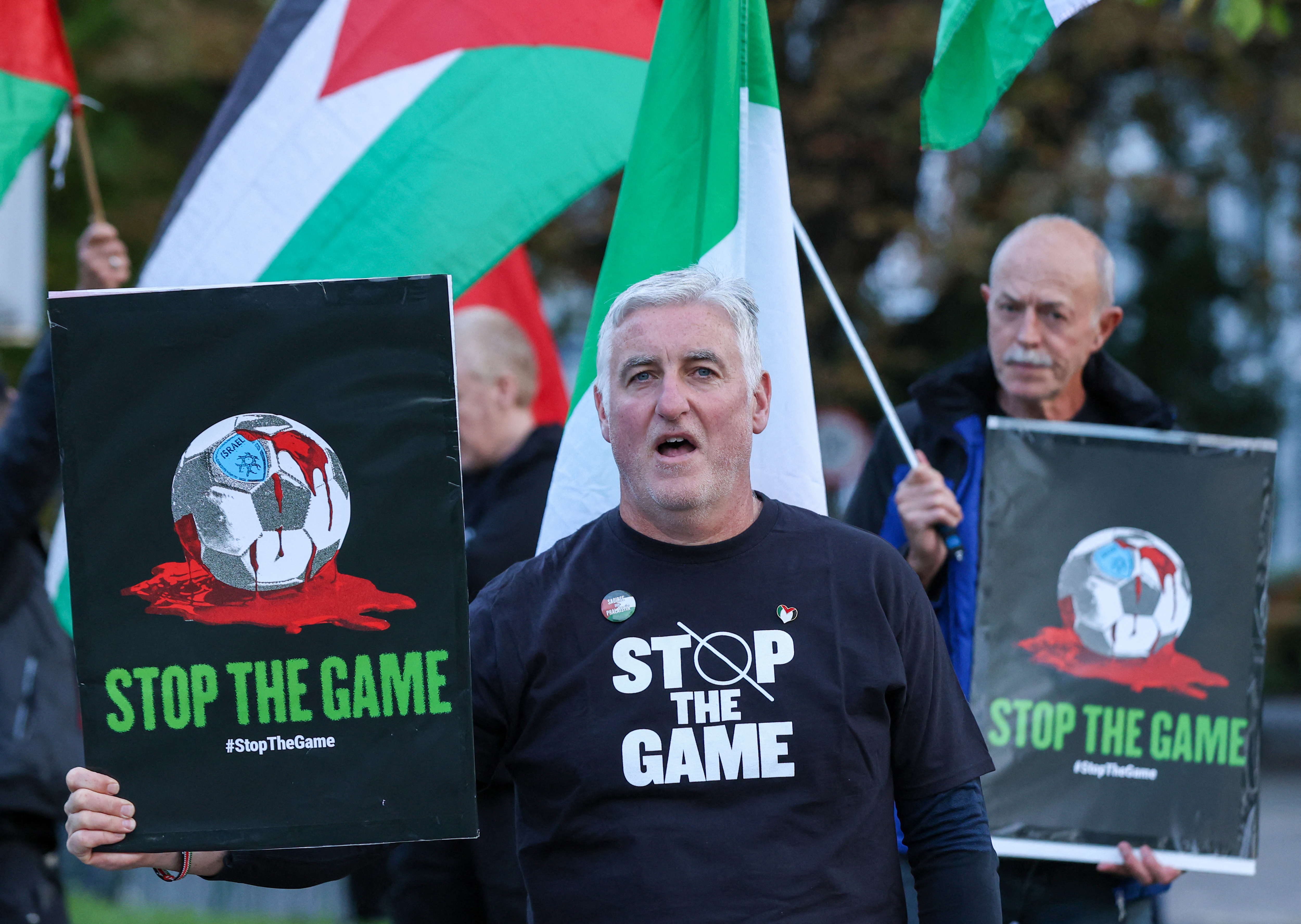 People hold placards calling on Ireland's football team not to play their next fixture against Israel, during a 'Stop The Game' protest outside Aviva Stadium in Dublin on October 1, 2026, ahead of the team's Nations League match against Austria. Ireland coach Heimir Hallgrimsson said on September 30 they will play their second Nations League match against Israel on October 4 after the first fixture was thrown into doubt by player concerns over the Gaza war. (Photo by Paul Faith / AFP)