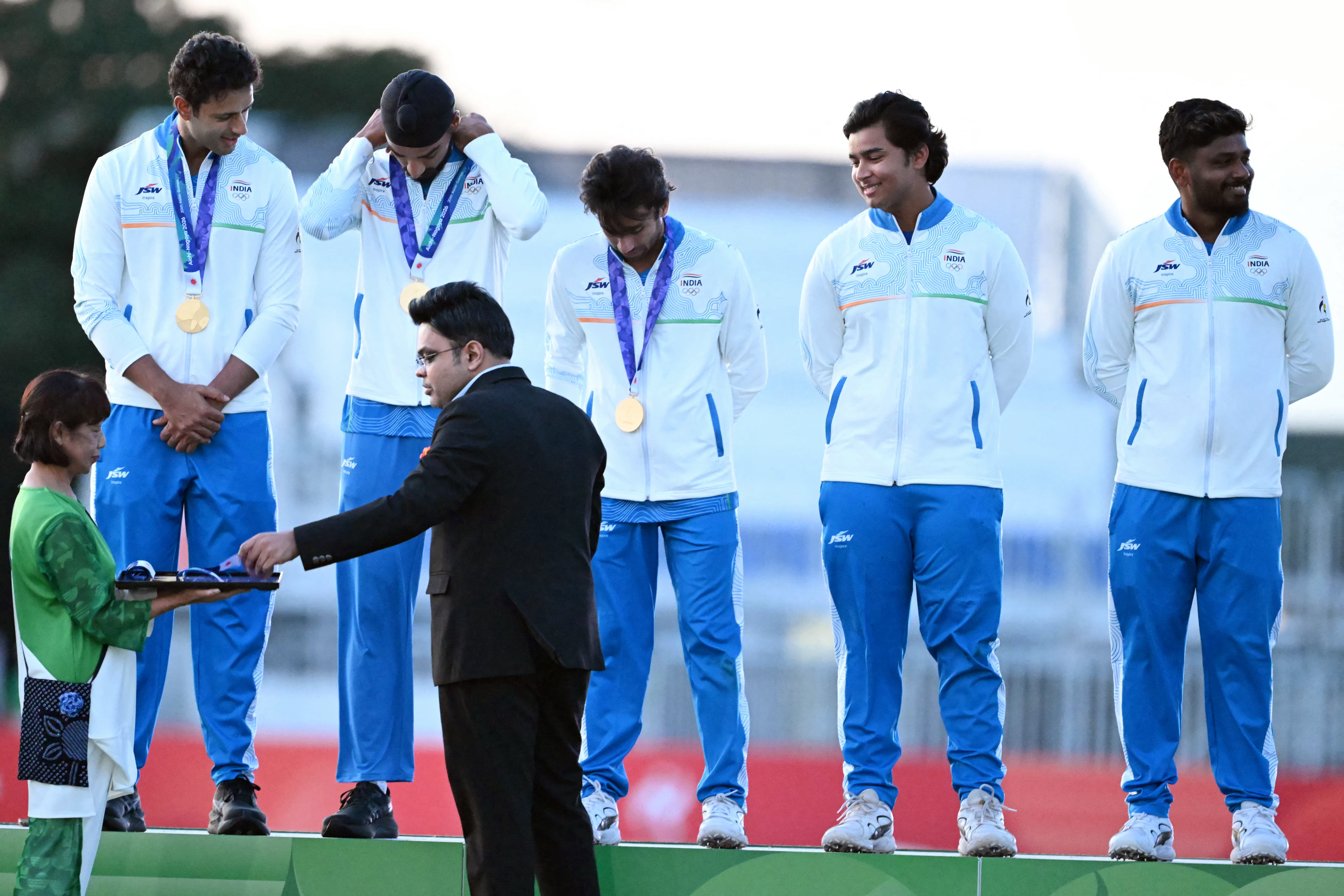 Gold medallists India stand on the podium as they receive medals from ICC chief Jay Shah during the victory ceremony for the men's cricket in the 2026 Asian Games at the Korogi Athletic Park in Nisshin on October 3, 2026. (Photo by ANDREW CABALLERO-REYNOLDS / AFP)