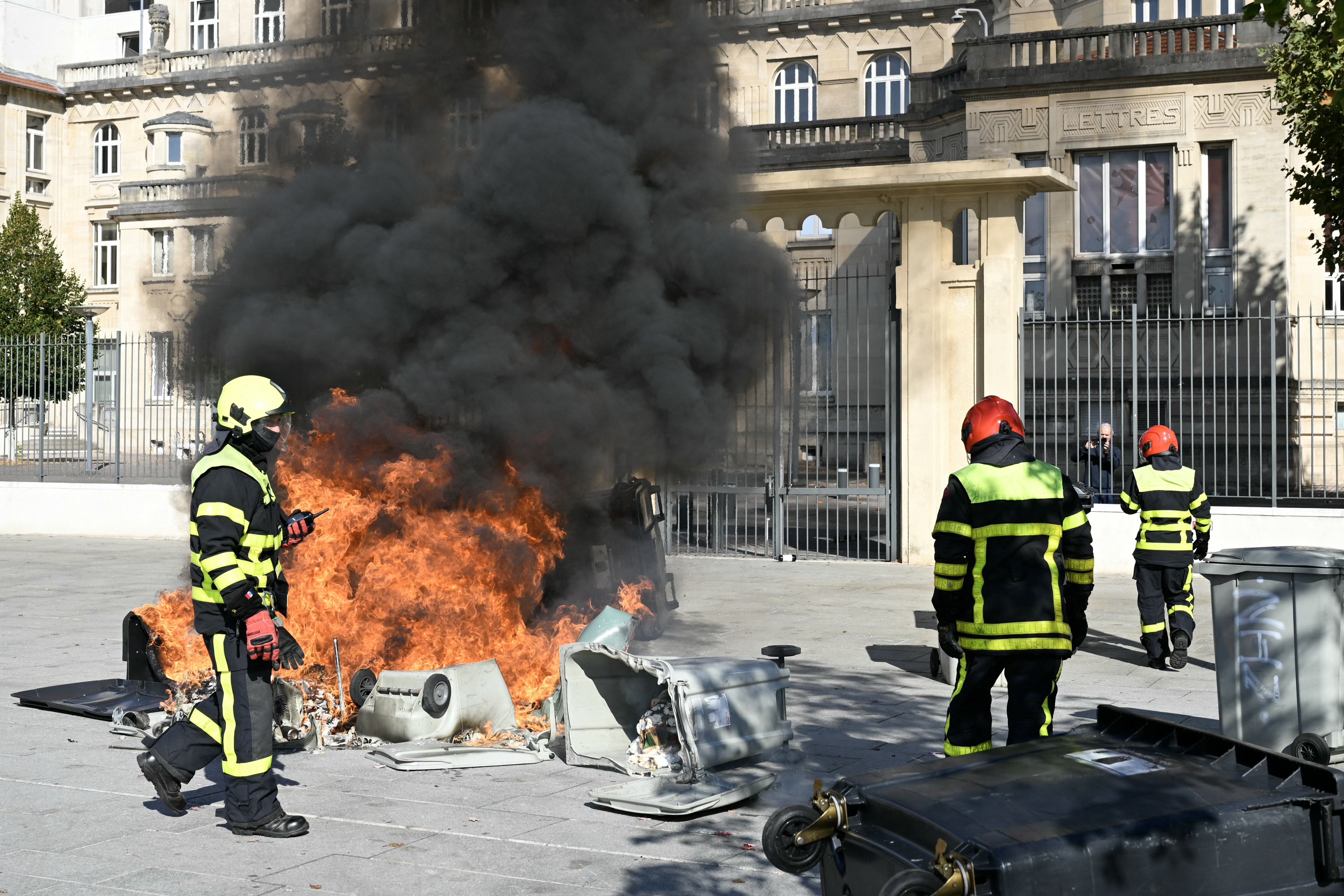 Firefighters arrive to extinguish a fire in front of Jean-Louis Cyffle high-school on the sidelines