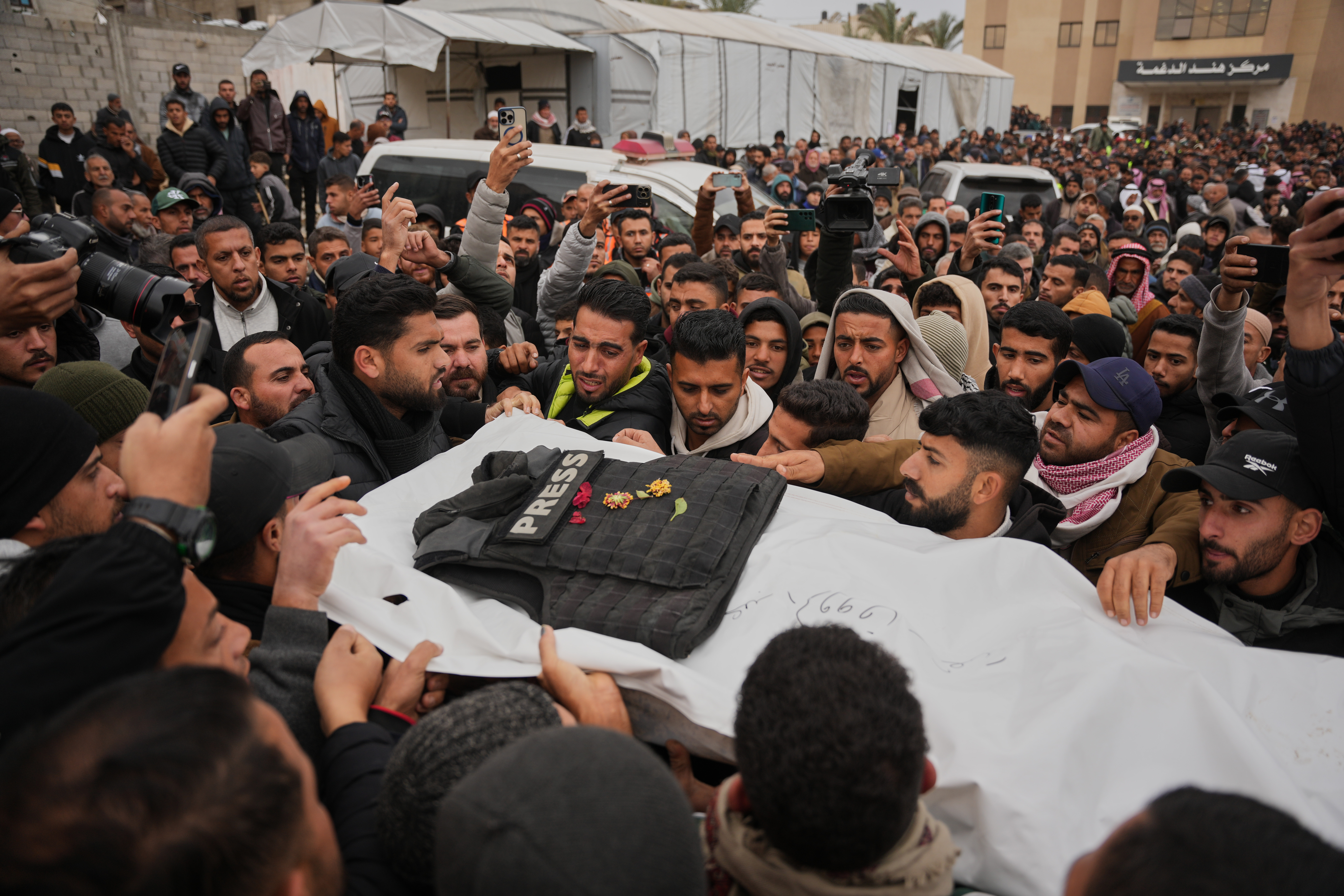 Mourners carry the body of Abd Shaat, one of the three Palestinian journalists killed in an Israeli attack during his funeral in Khan Younis, southern Gaza, on January 22, 2026