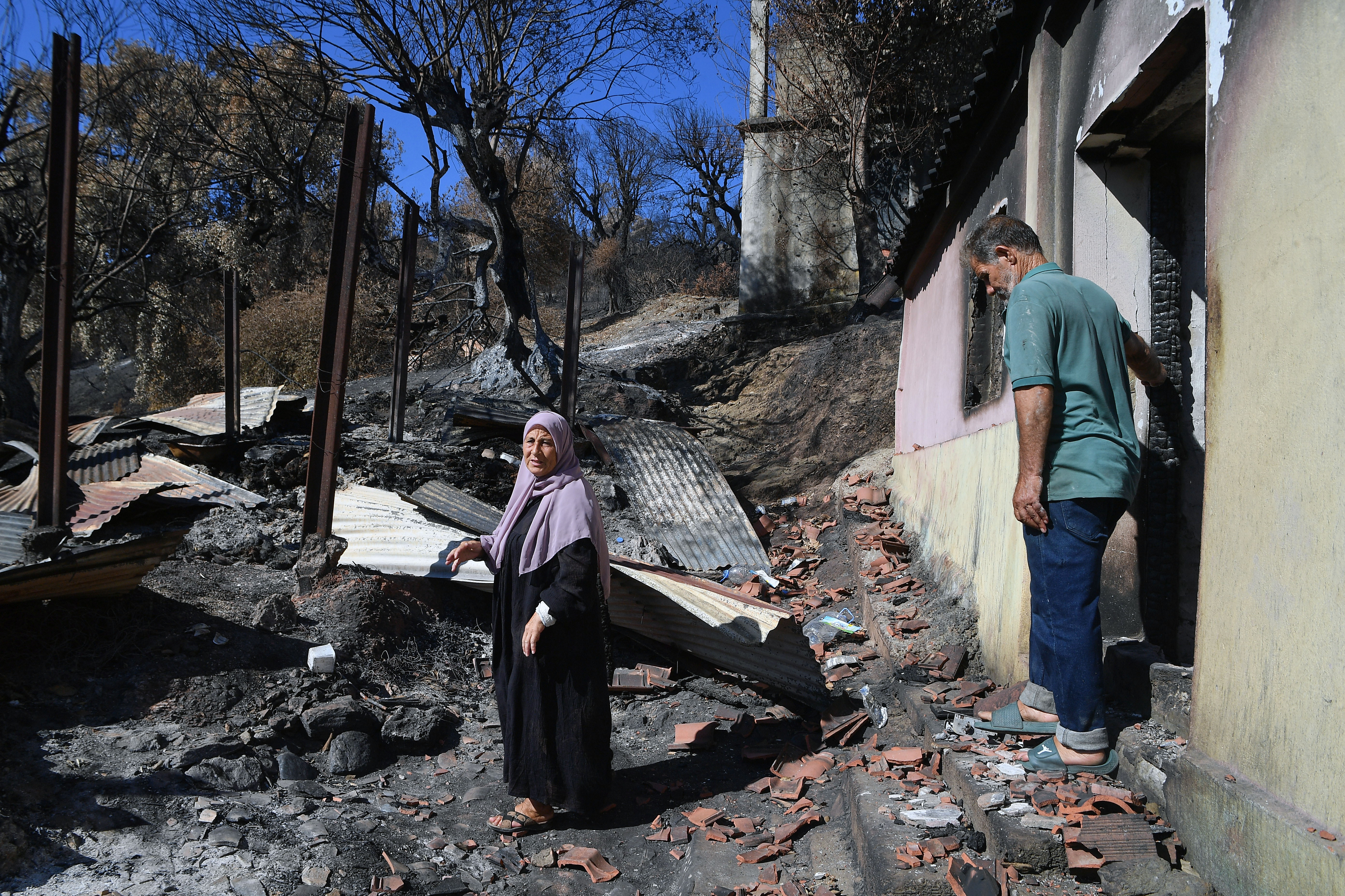A couple inspects their home, which was damaged by wildfires in the town of Djemaa Beni Habibi, Jijel, Algeria, Friday, September 4, 2026