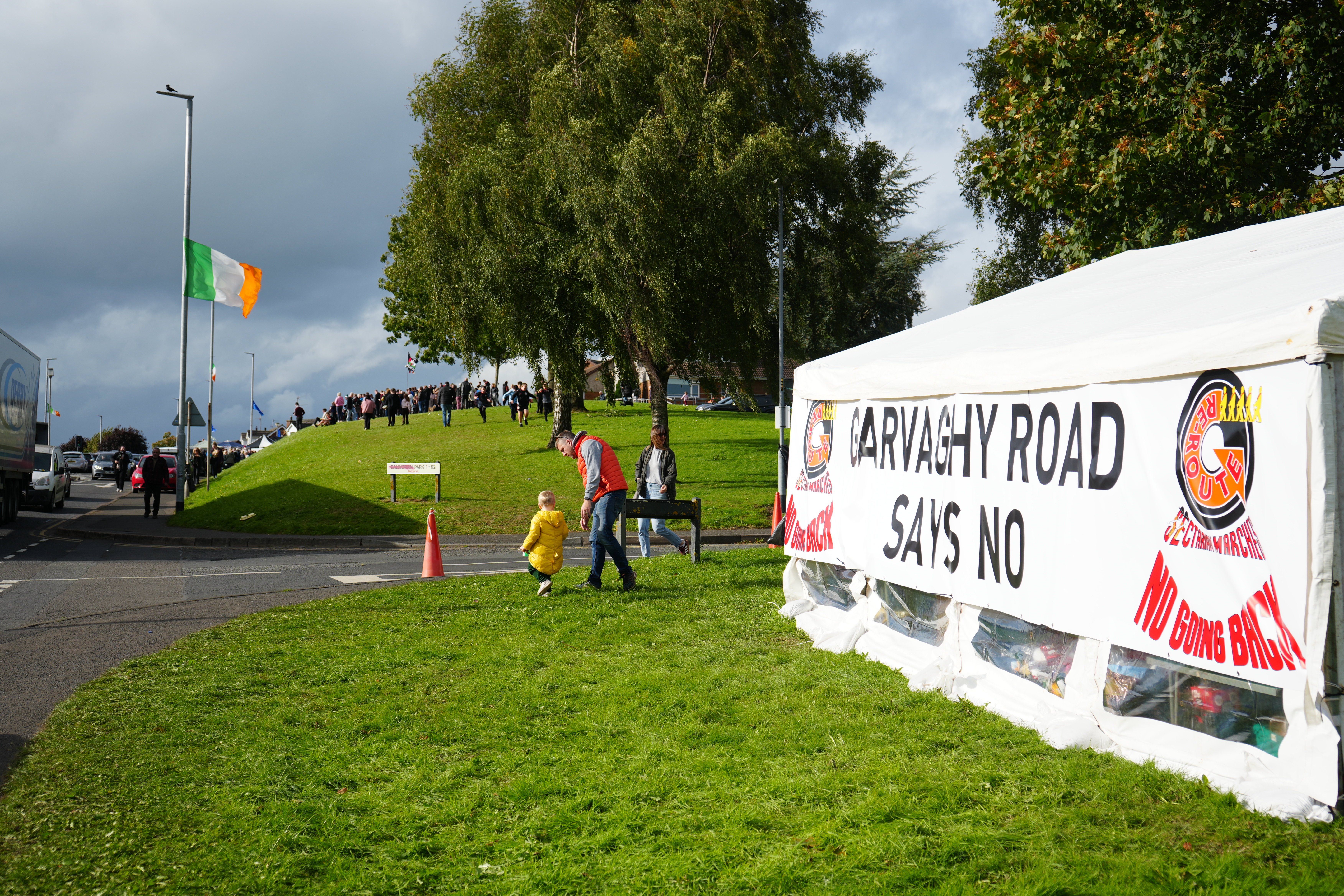 A ‘Garvaghy Road says no’ sign with an Irish tricolour in the background in Portadown, Northern Ireland, on October 1, 2026 [Caolán Magee]