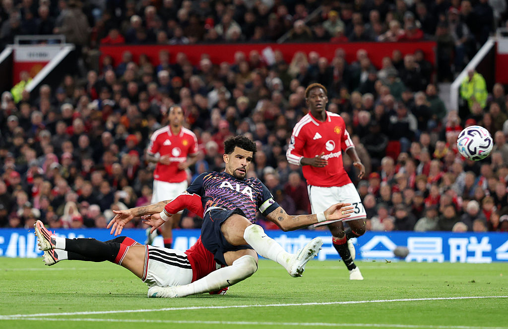 Dominic Solanke of Tottenham Hotspur shoots and is tackled by Lisandro Martinez of Manchester United