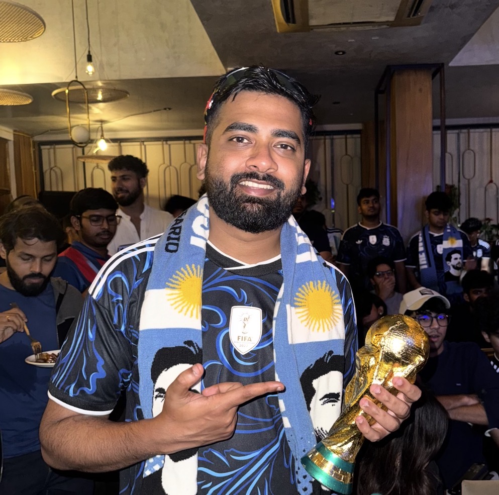 Sagar Shinde, an Argentina fan from Mumbai, India, poses with a miniature of the FIFA World Cup at a screening [Courtesy of Sagar Shinde]