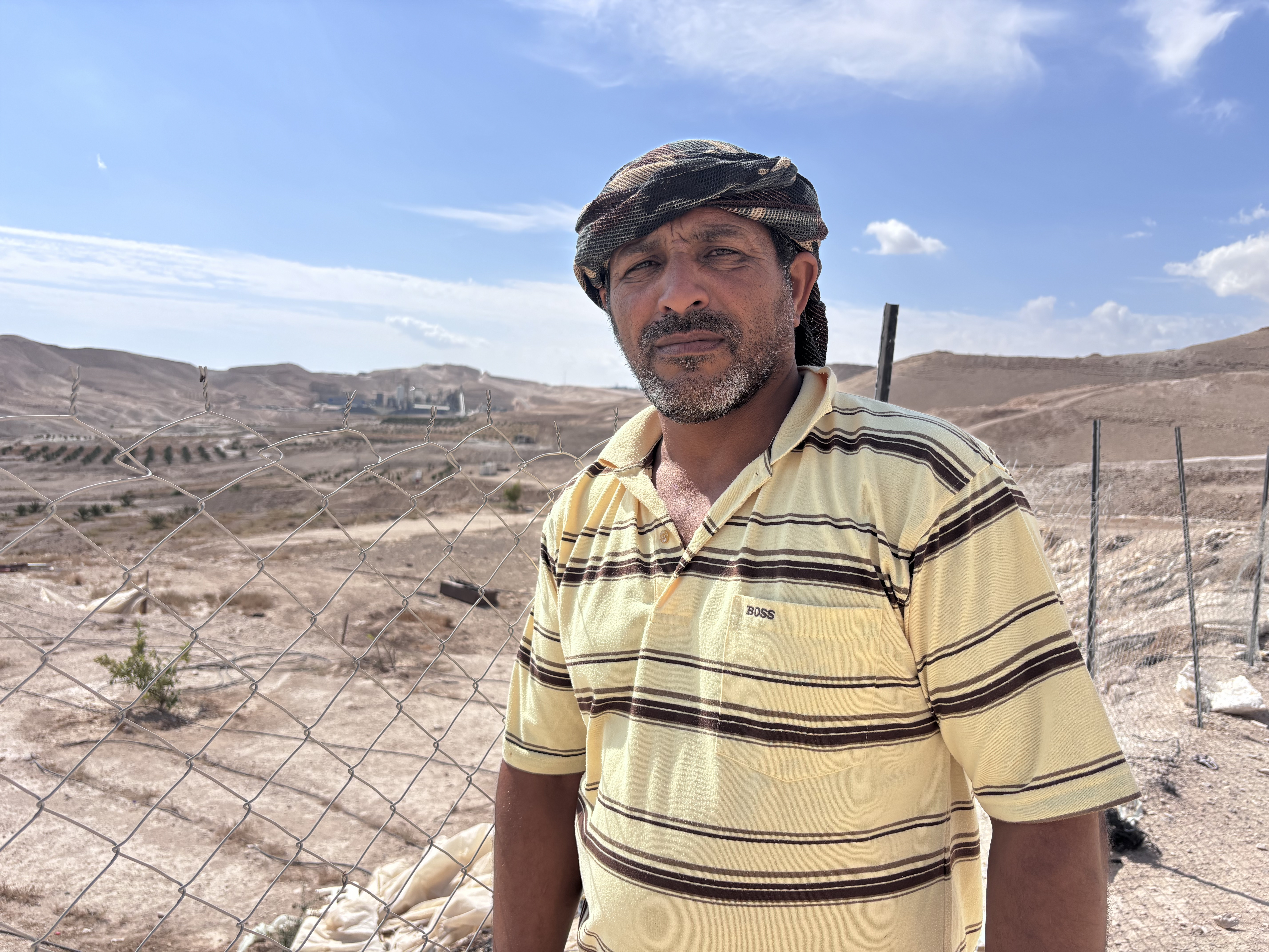 Man stands with rocky landscape behind him
