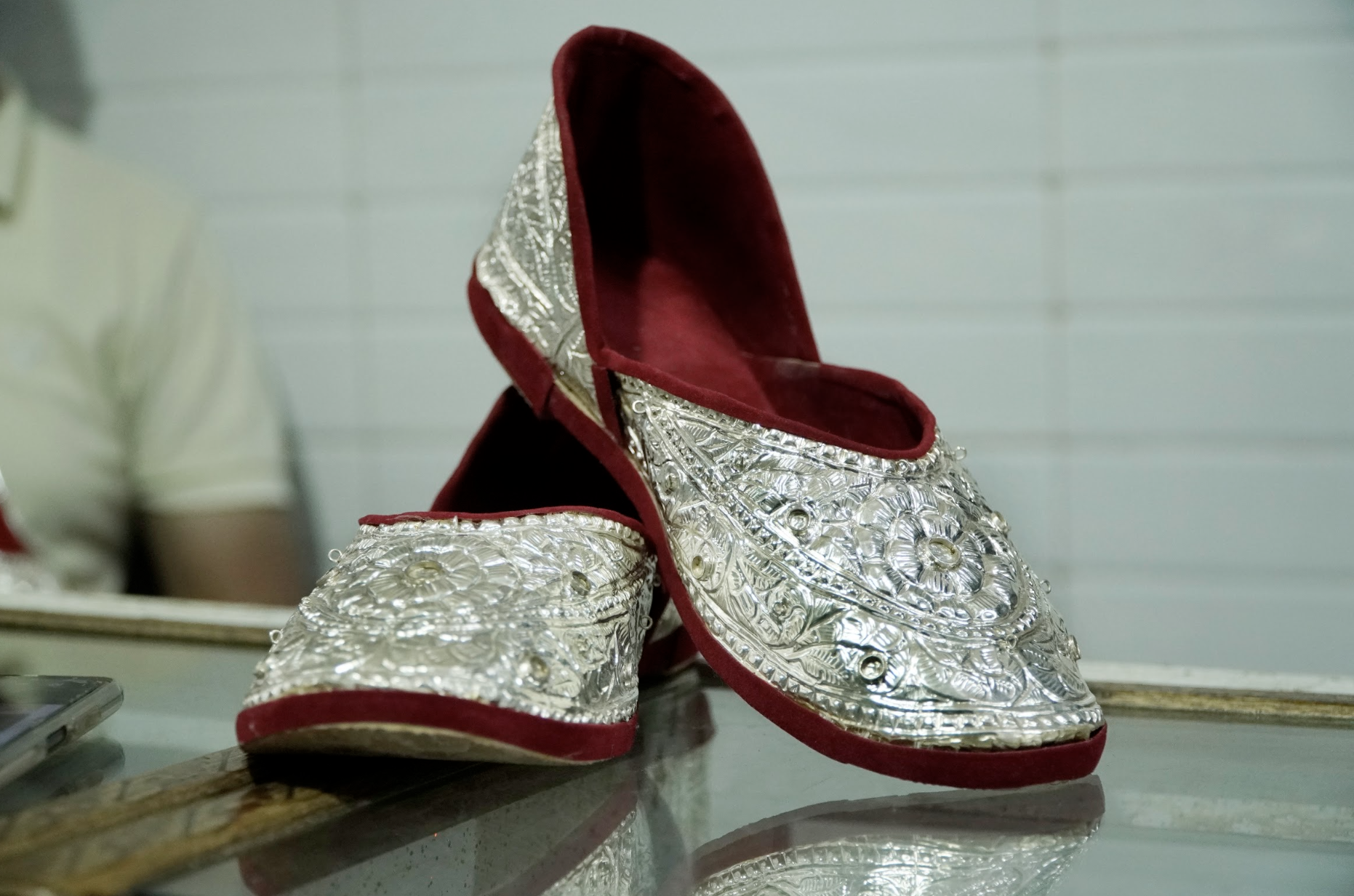 Uzma Siddique’s silver nagras are intricately handcrafted sandals featuring traditional floral and geometric designs. Made with less silver than nagras produced a few years ago, the pair is lighter in weight and more affordable [Aatif Ammad/Al Jazeera]