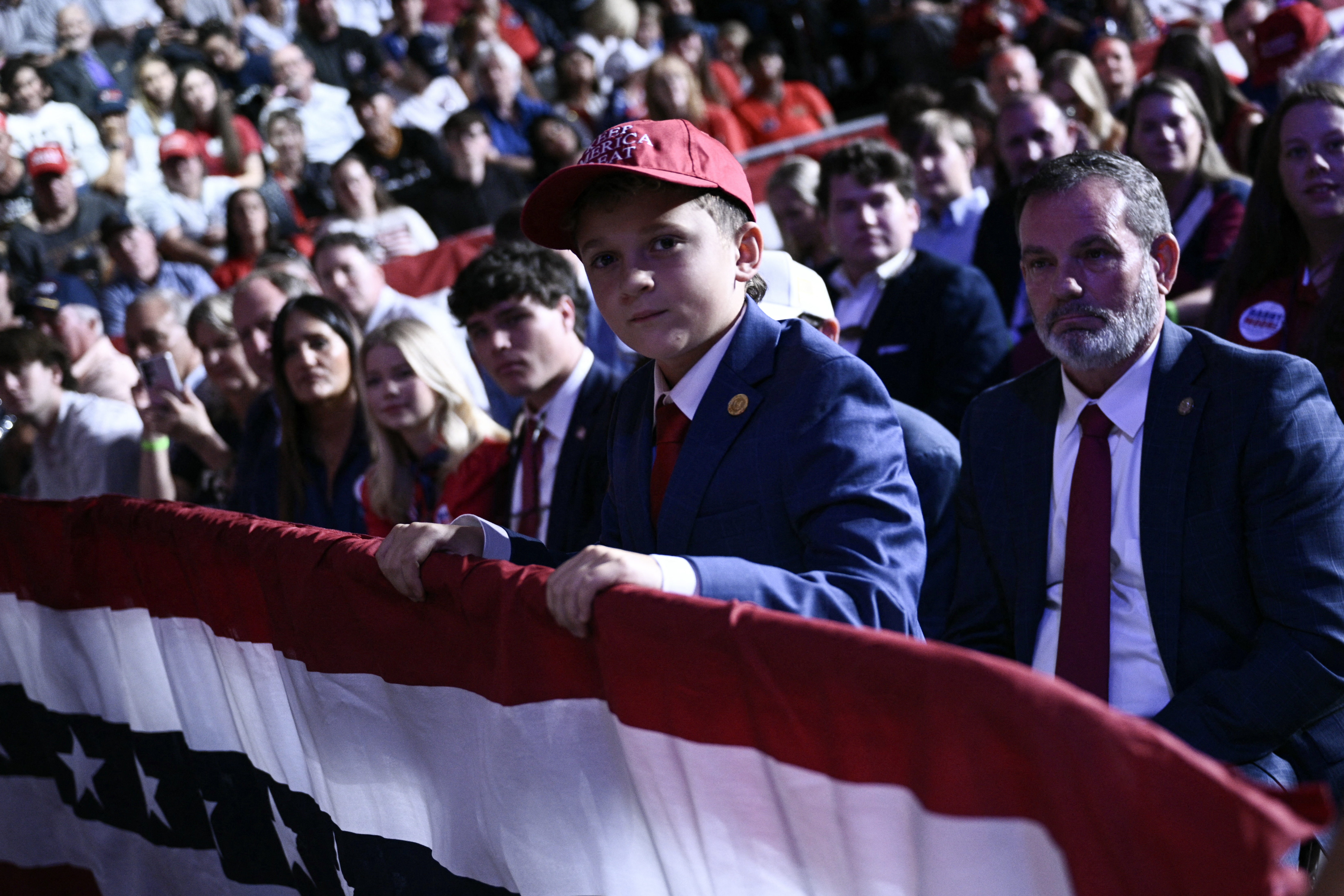 A young support of US President Donald Trump watches him speak during a midterm campaign rally at The Mitchell Center of the University of South Alabama in Mobile, Alabama on October 2, 2026. (Photo by Brendan SMIALOWSKI / AFP)