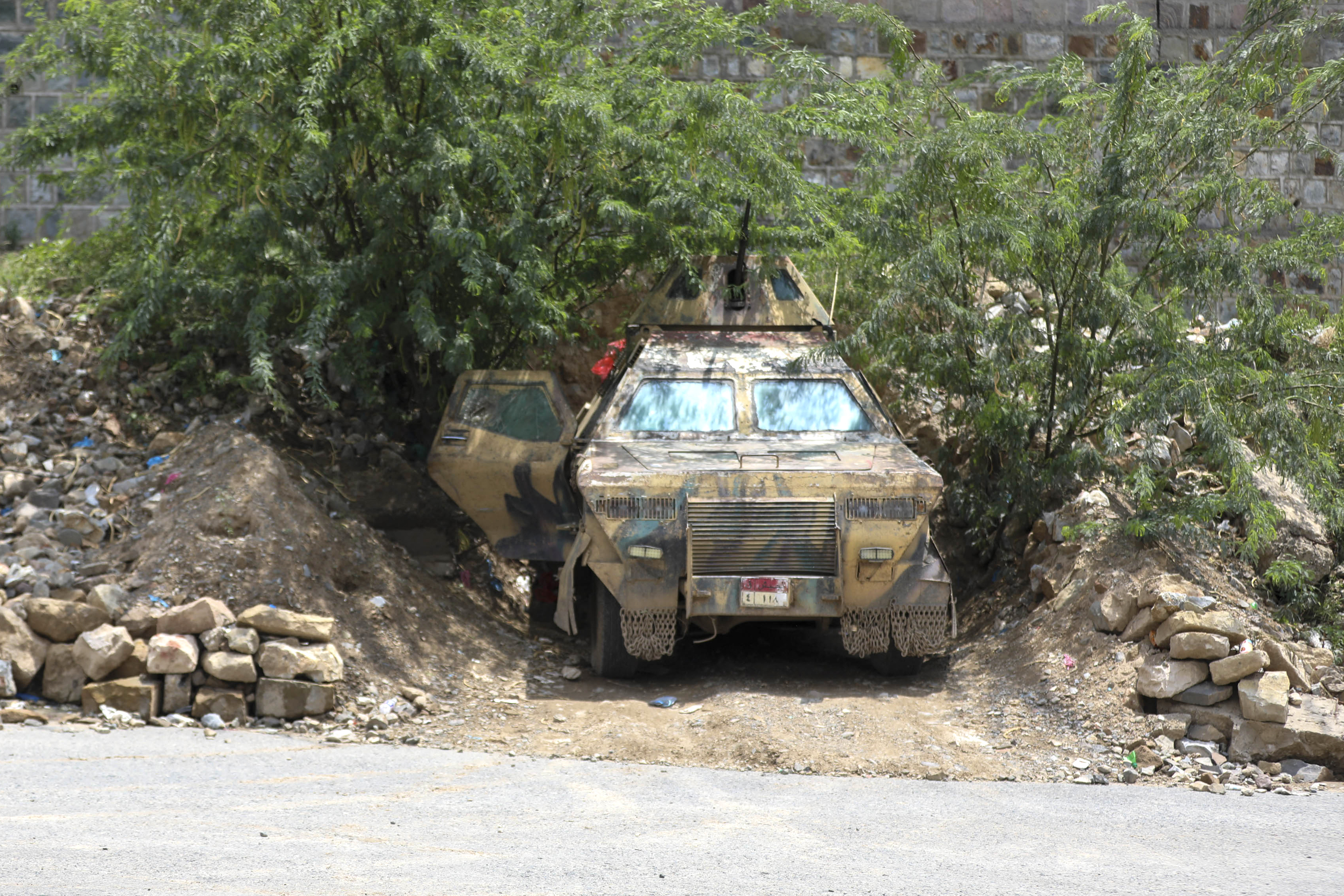 An armoured vehicle belonging to the Saudi-backed Yemeni government forces is stationed under a tree near to the Jabal Han front west of the city of Taiz following fierce battles earlier in the day as Yemen's Houthis reportedly attempted to seize control of the main route between the inland city of Taiz and the coastal city of Aden, on October 3, 2026.
