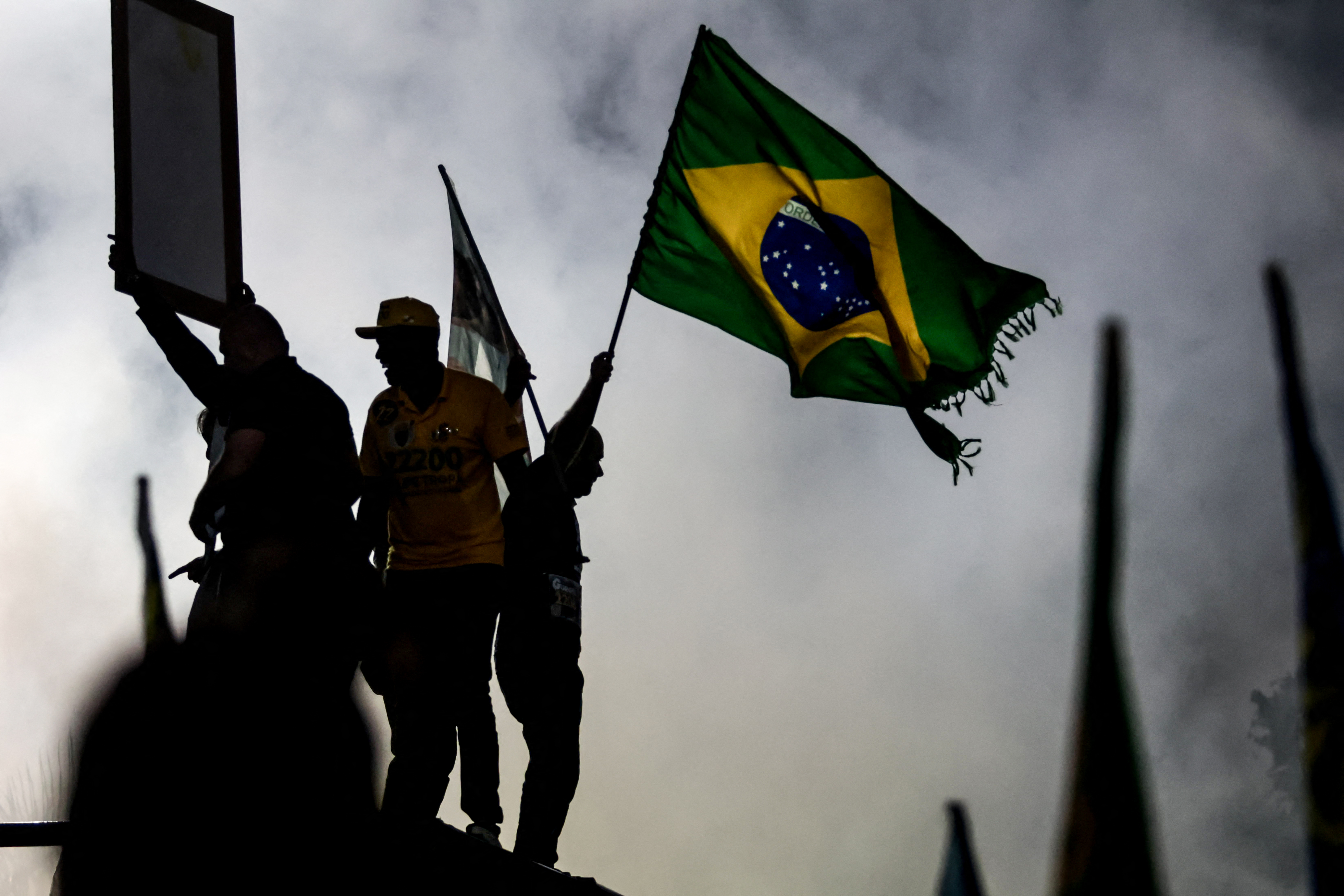 A supporter of Brazil’s right-wing senator and presidential candidate Flavio Bolsonaro of the Liberal Party (PL) waves a natinal flag during a campaign rally on the eve of the general election in the Bangu neighborhood, in Rio de Janeiro’s West Zone, on October 3, 2026.