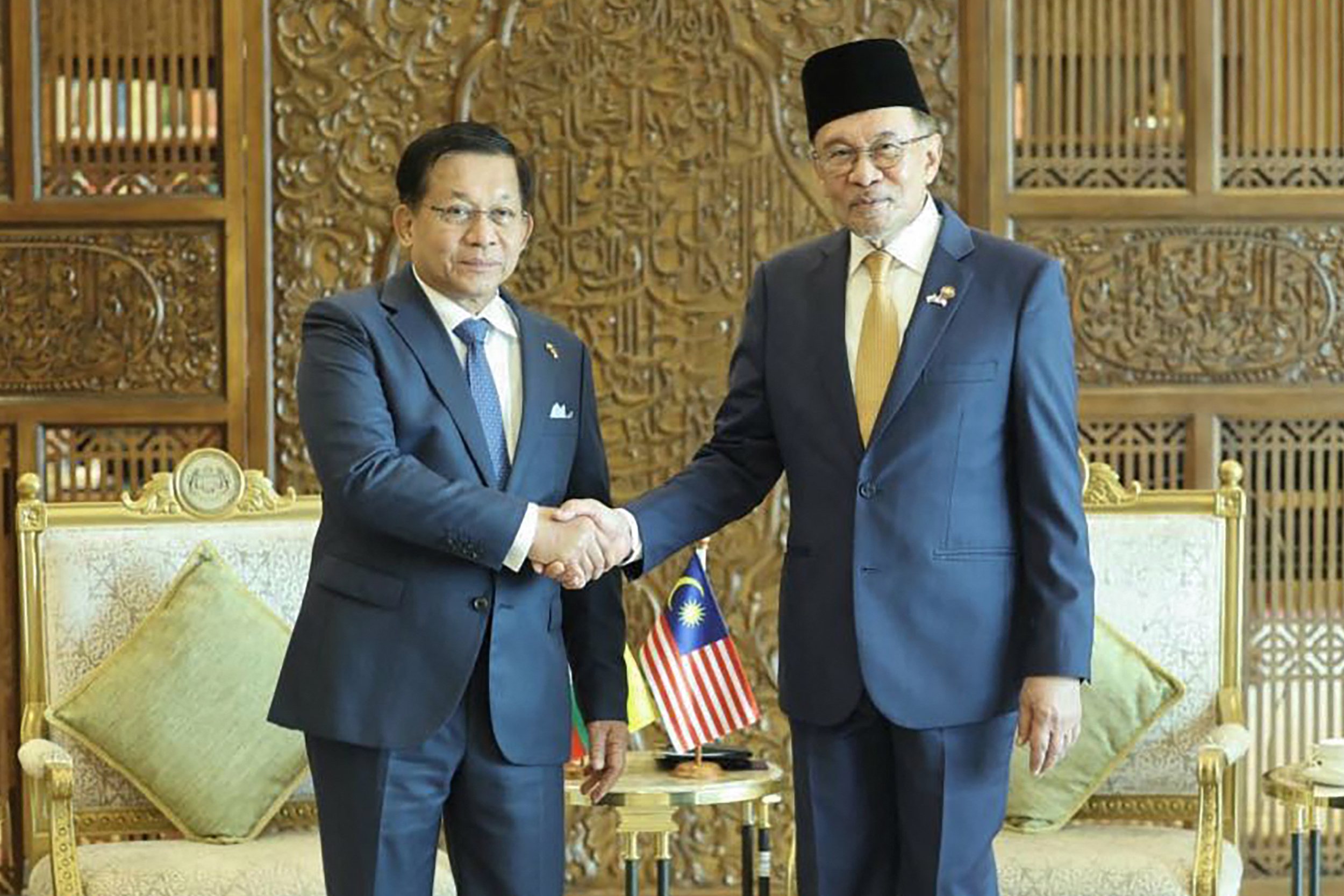 Myanmar's President Min Aung Hlaing (L) shaking hands with Malaysia's Prime Minister Anwar Ibrahim.