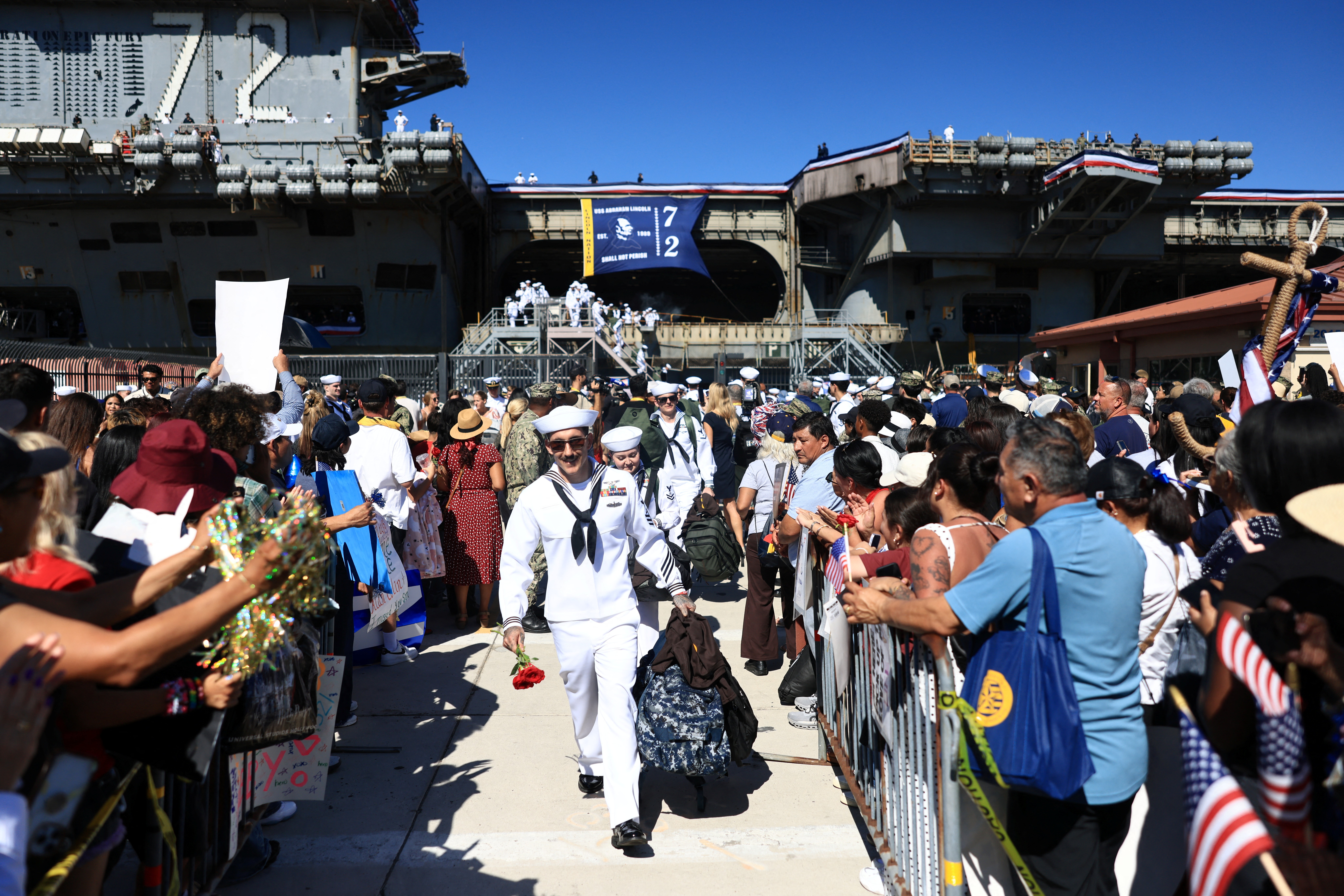 Sailors disembark the US Navy aircraft carrier USS Abraham Lincoln (CVN-72) which arrived at Naval Air Station North Island in San Diego, California, on October 8, 2026