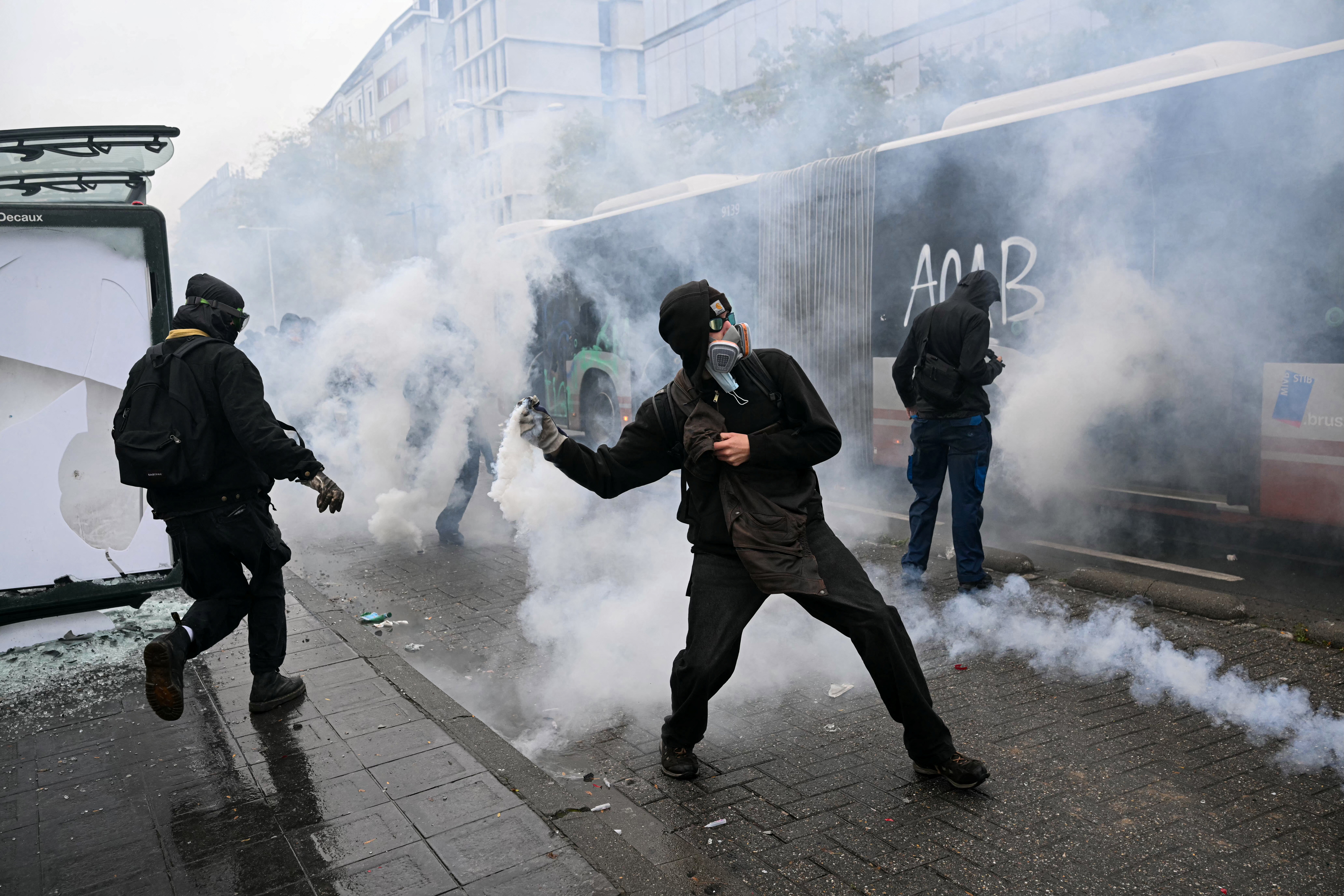 A protester prepares to launch a tear gas canister during a labour union-based demonstration against the Federal Government's budgetary measures near the Brussels-South railway station in Brussels on October 9, 2026.