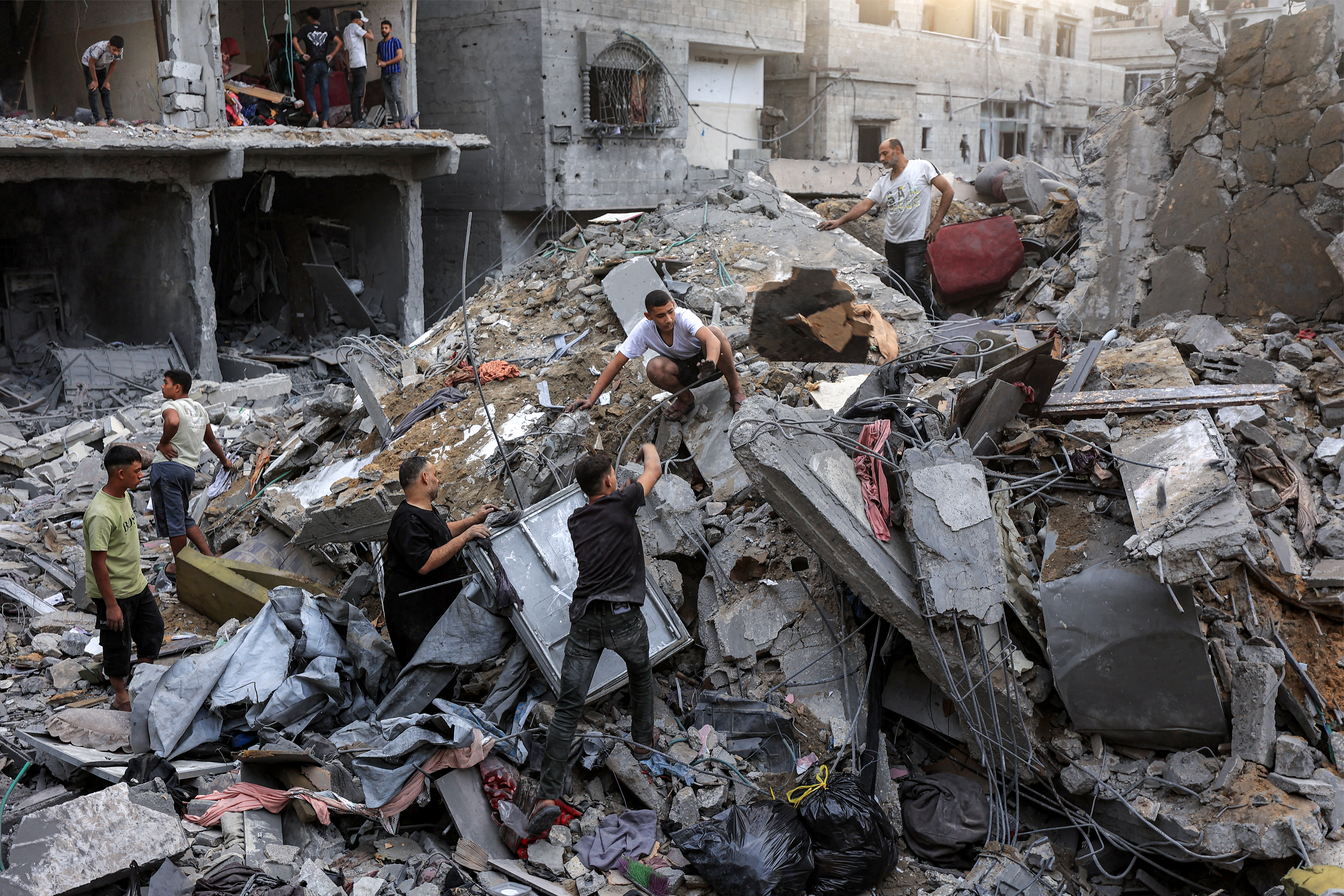 People search the rubble of a collapsed building following overnight Israeli airstrikes in Gaza City on October 9, 2026, before which the Israeli military had warned residents to evacuate the area.